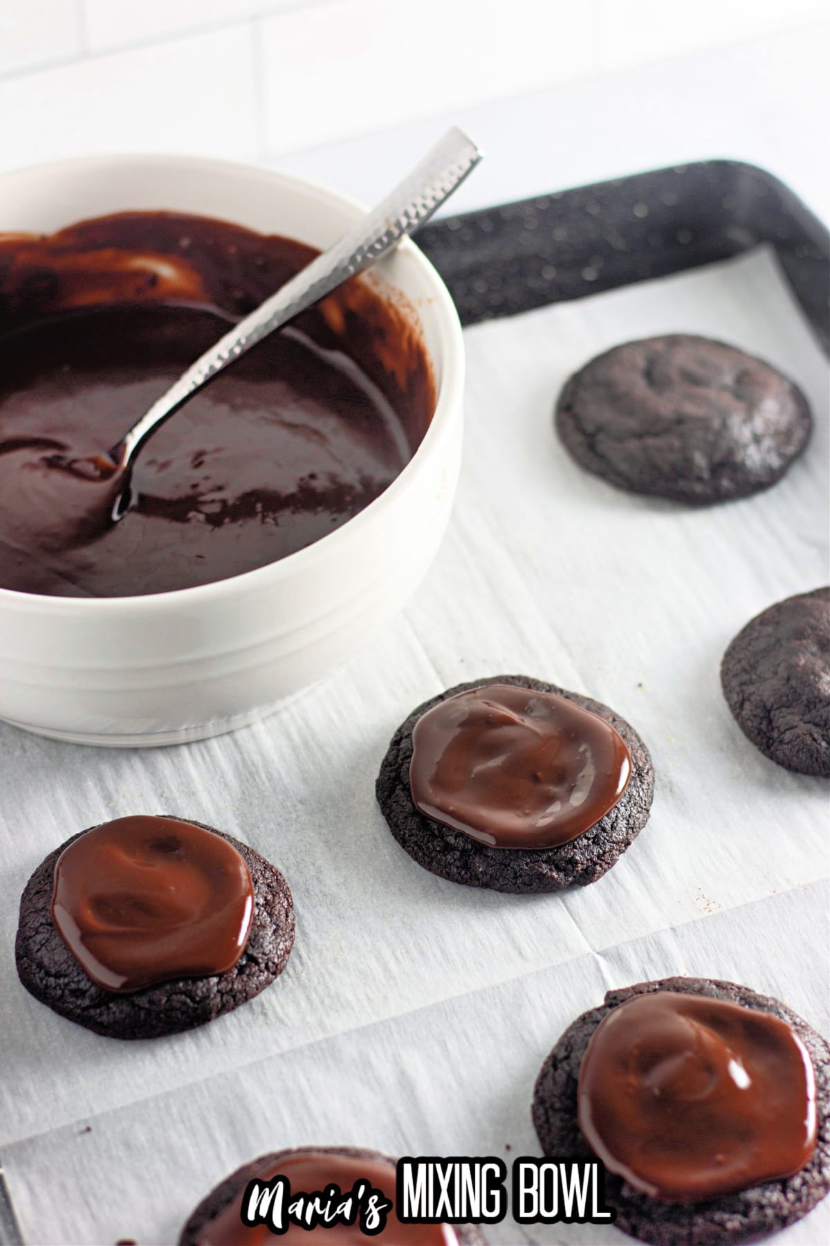 chocolate ganache being added to the top of cookies.