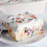 slice of funfetti cake on a white plate with a fork.
