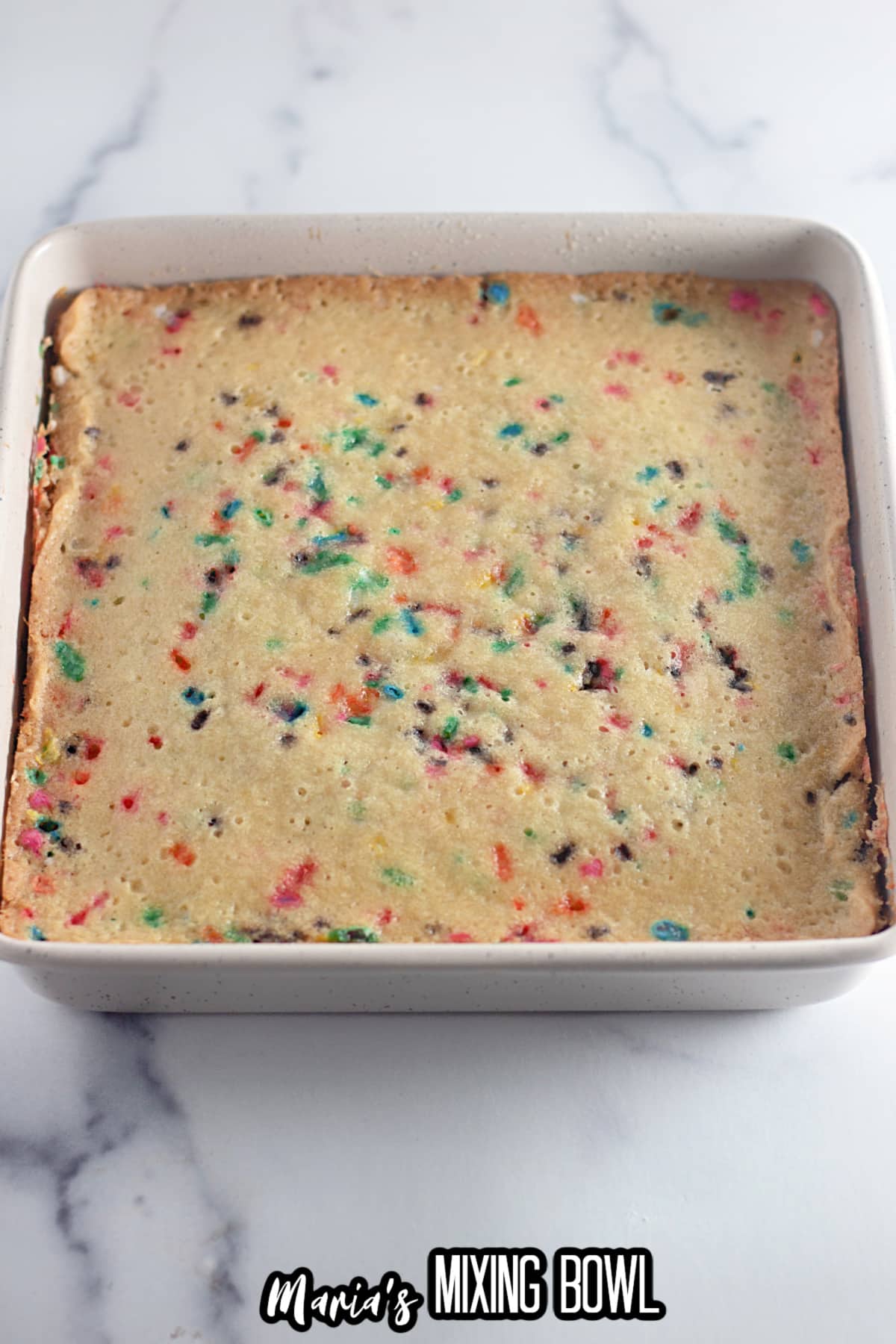 baked funfetti cake in a square baking dish.