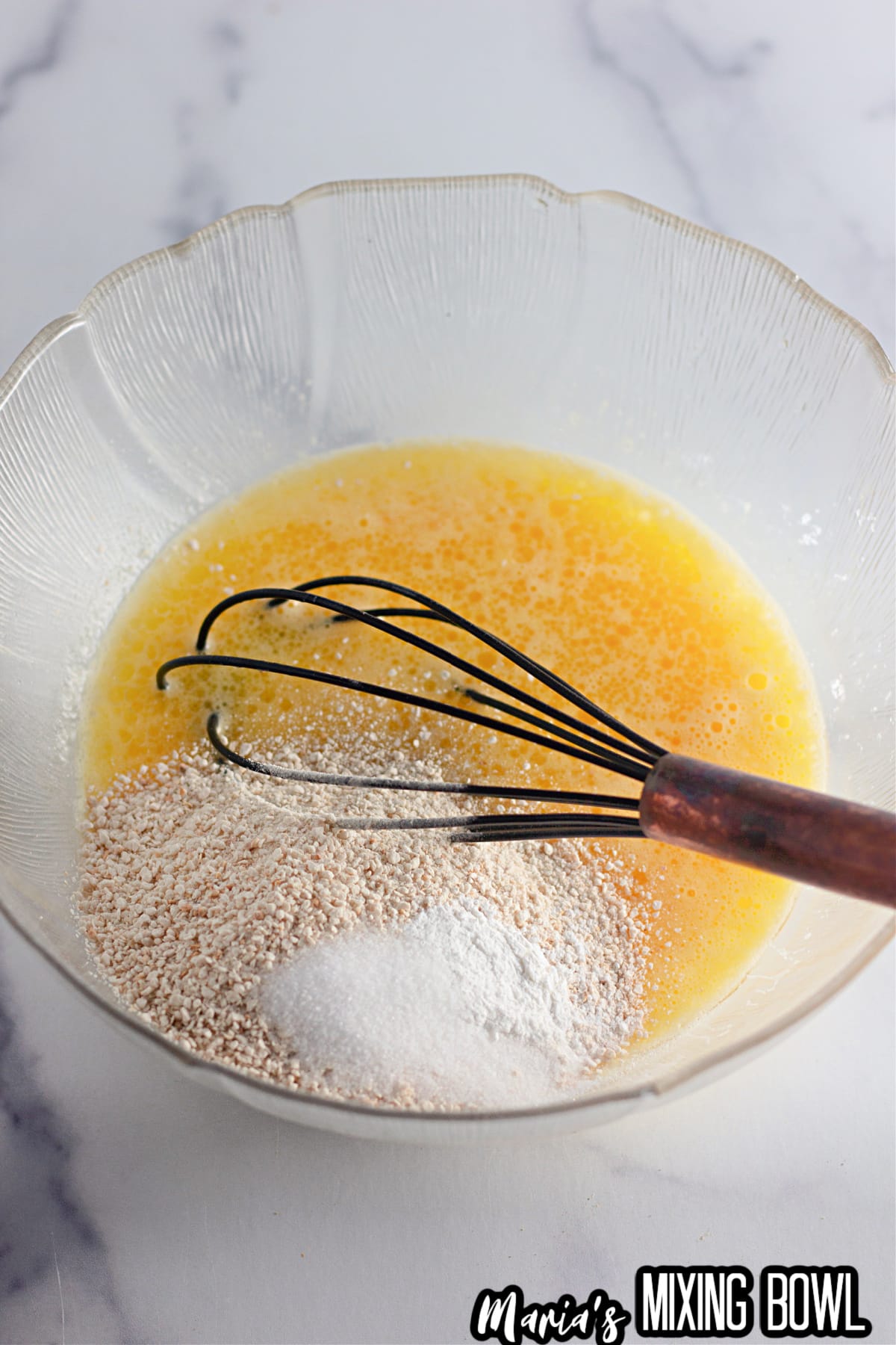 matzo ball dough being made in a glass bowl.