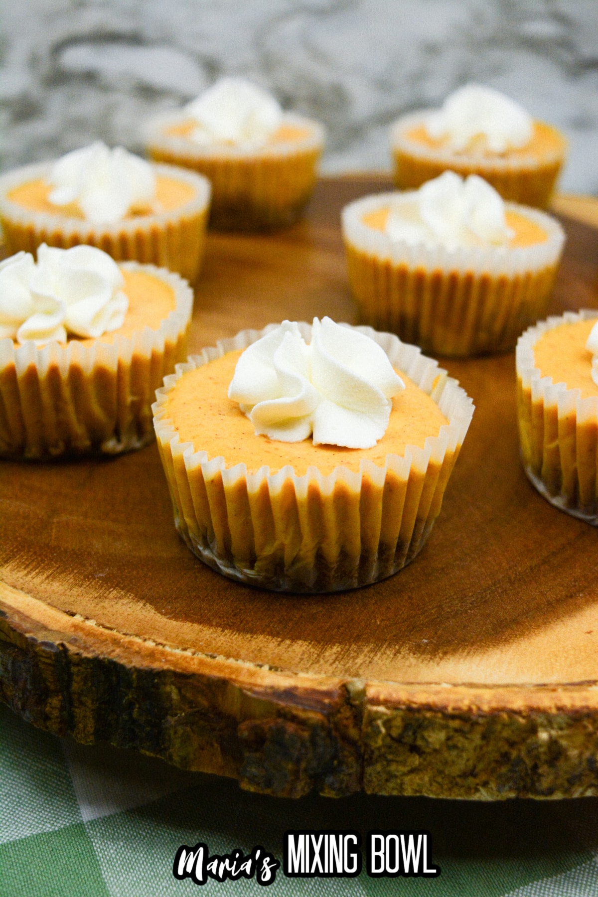 mini pumpkin pie cheesecakes on a wooden cutting board.