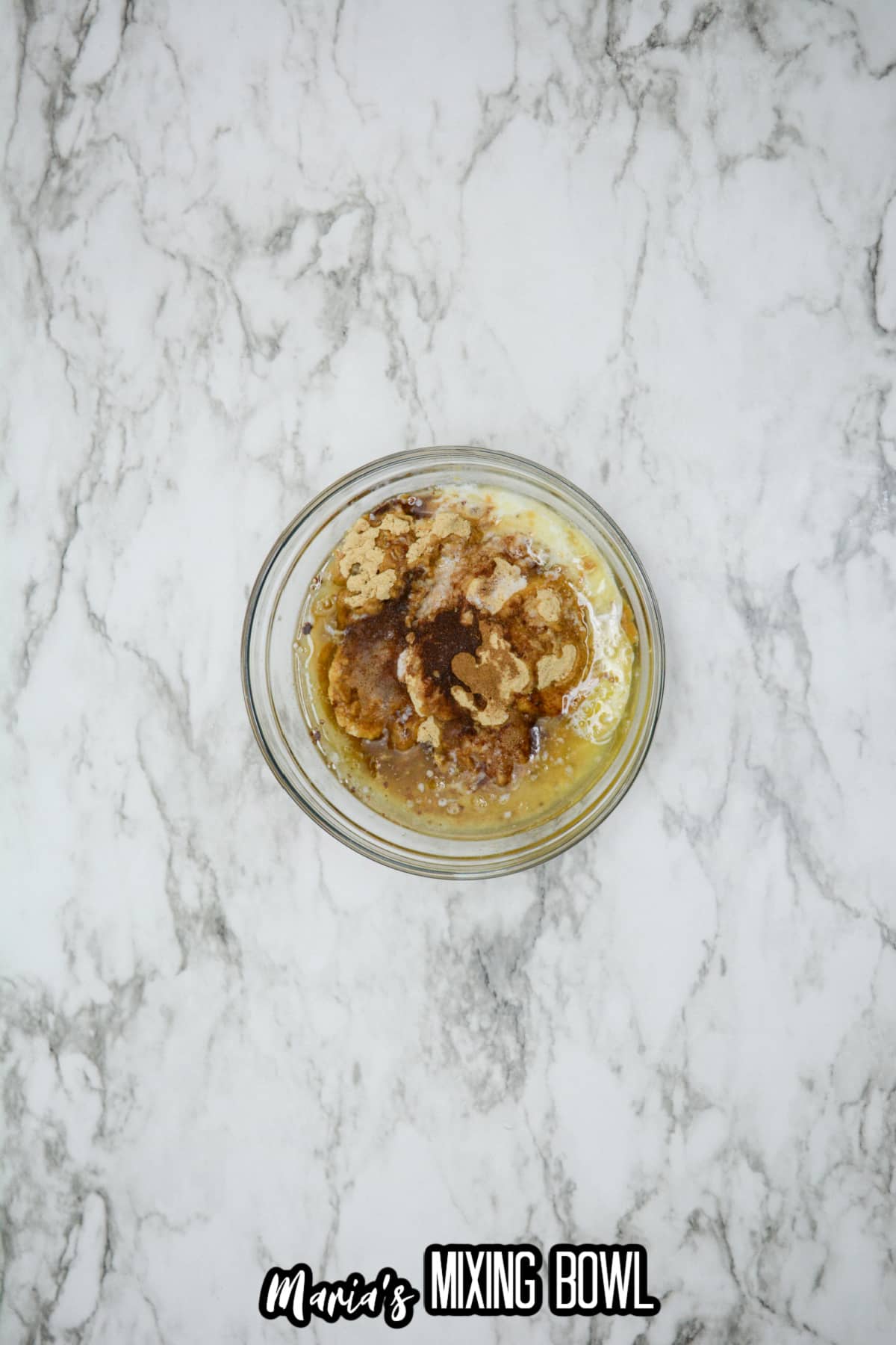 graham cracker crumbs, sugar, and melted butter being mixed in a small glass bowl.