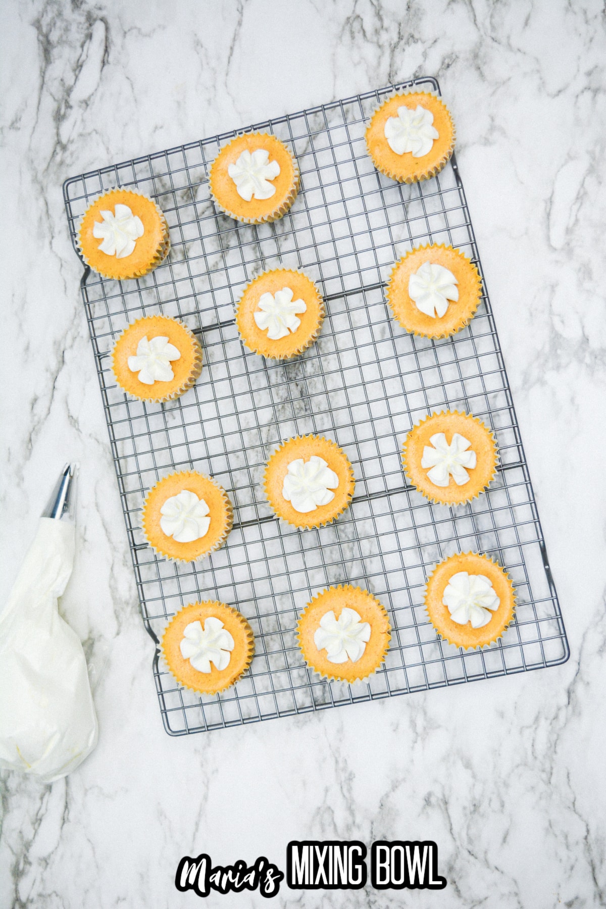 mini pumpkin pie cheesecakes cooling on a wire rack.