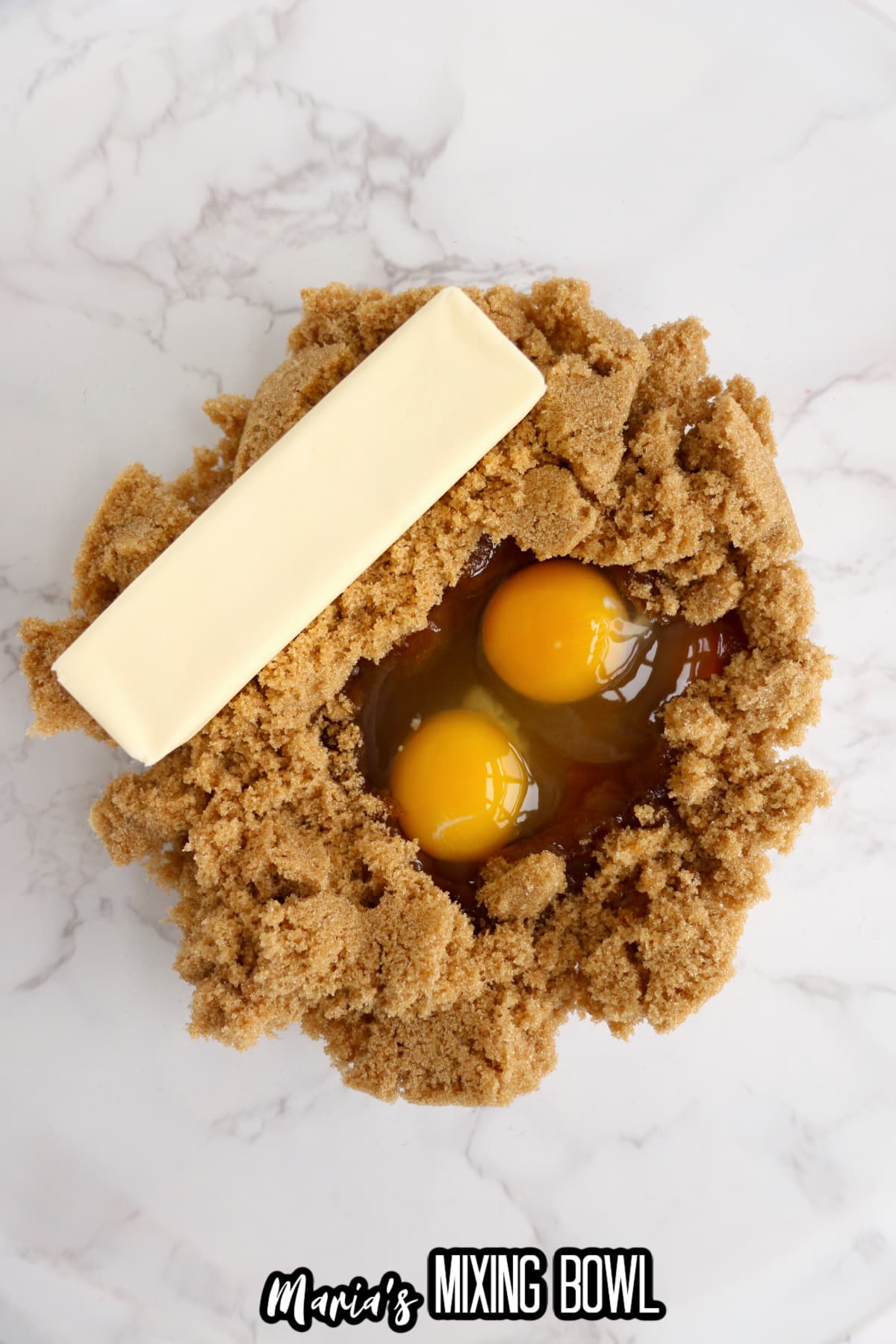 butter, brown sugar, and eggs being creamed together in a glass mixing.