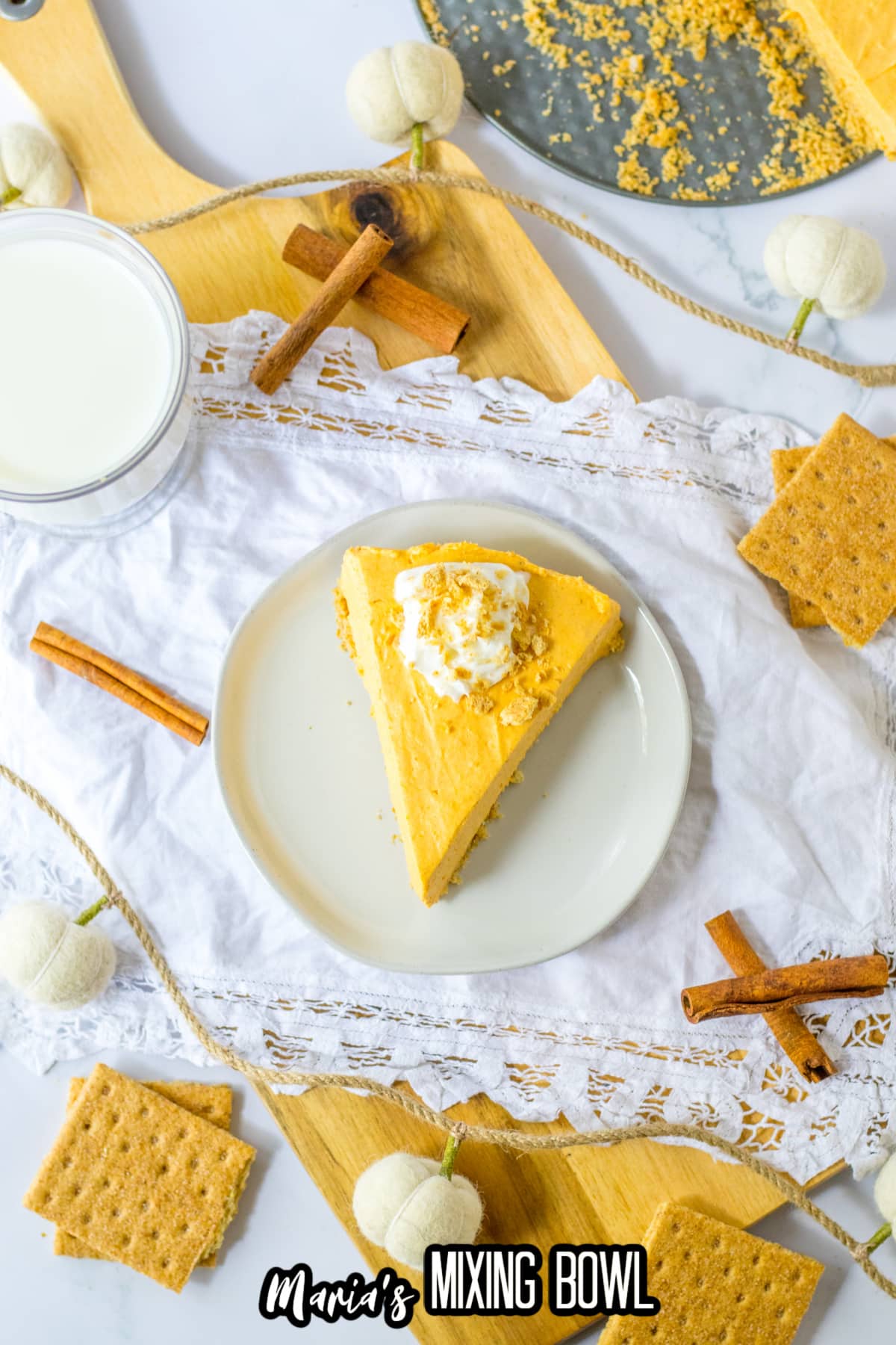slice of pumpkin cheesecake topped with whipped cream on a plate.