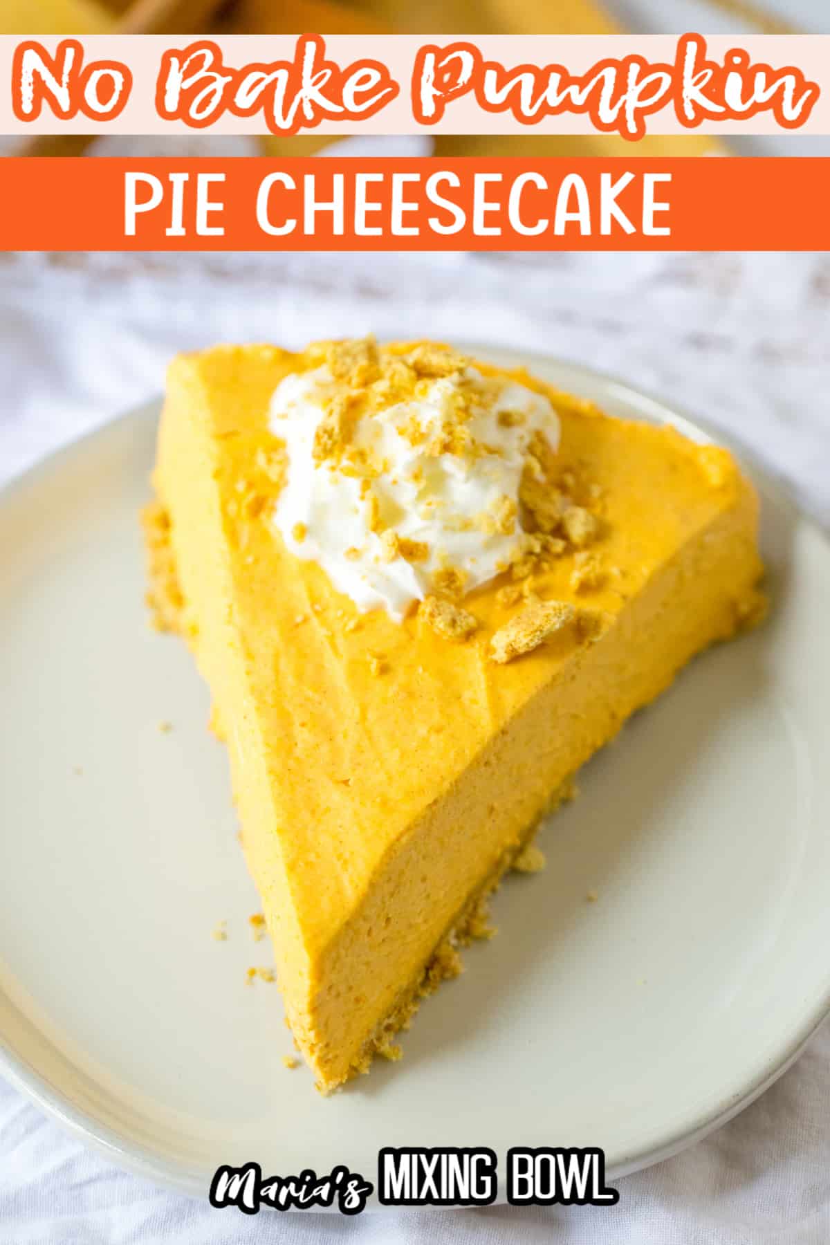 slice of pumpkin cheesecake topped with whipped cream on a plate.