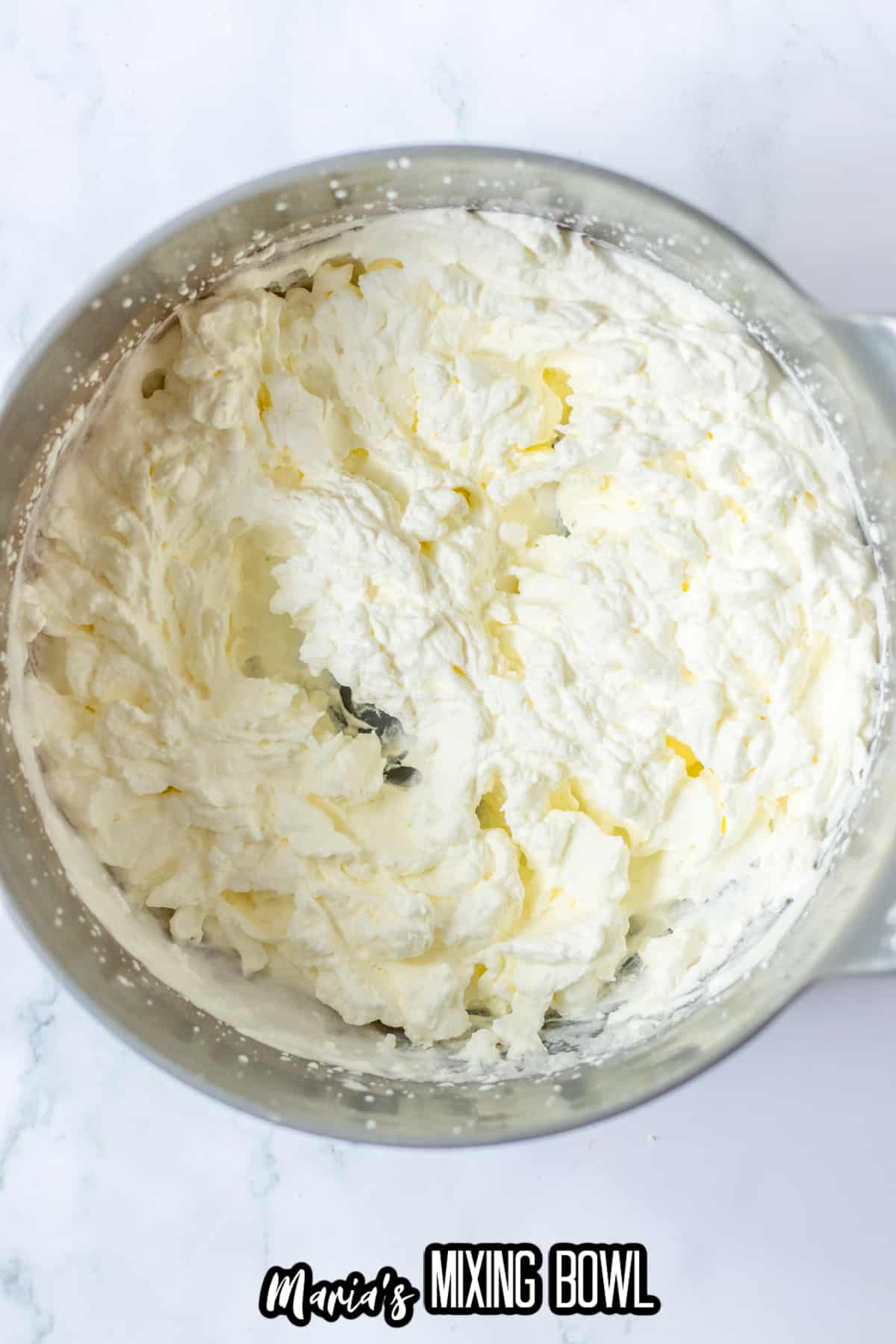 homemade whipped cream in stainless steel mixing bowl.