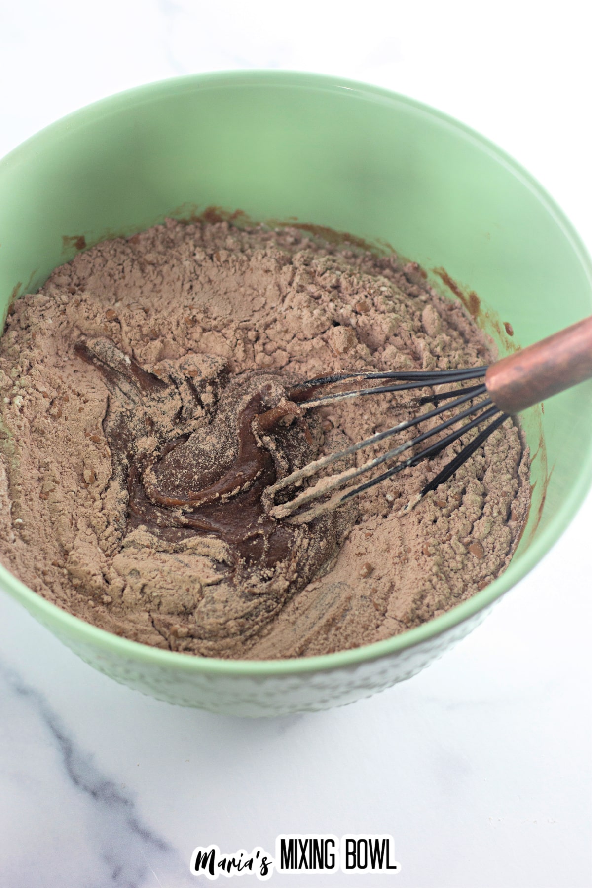 brownie batter in a mixing bowl with a whisk.