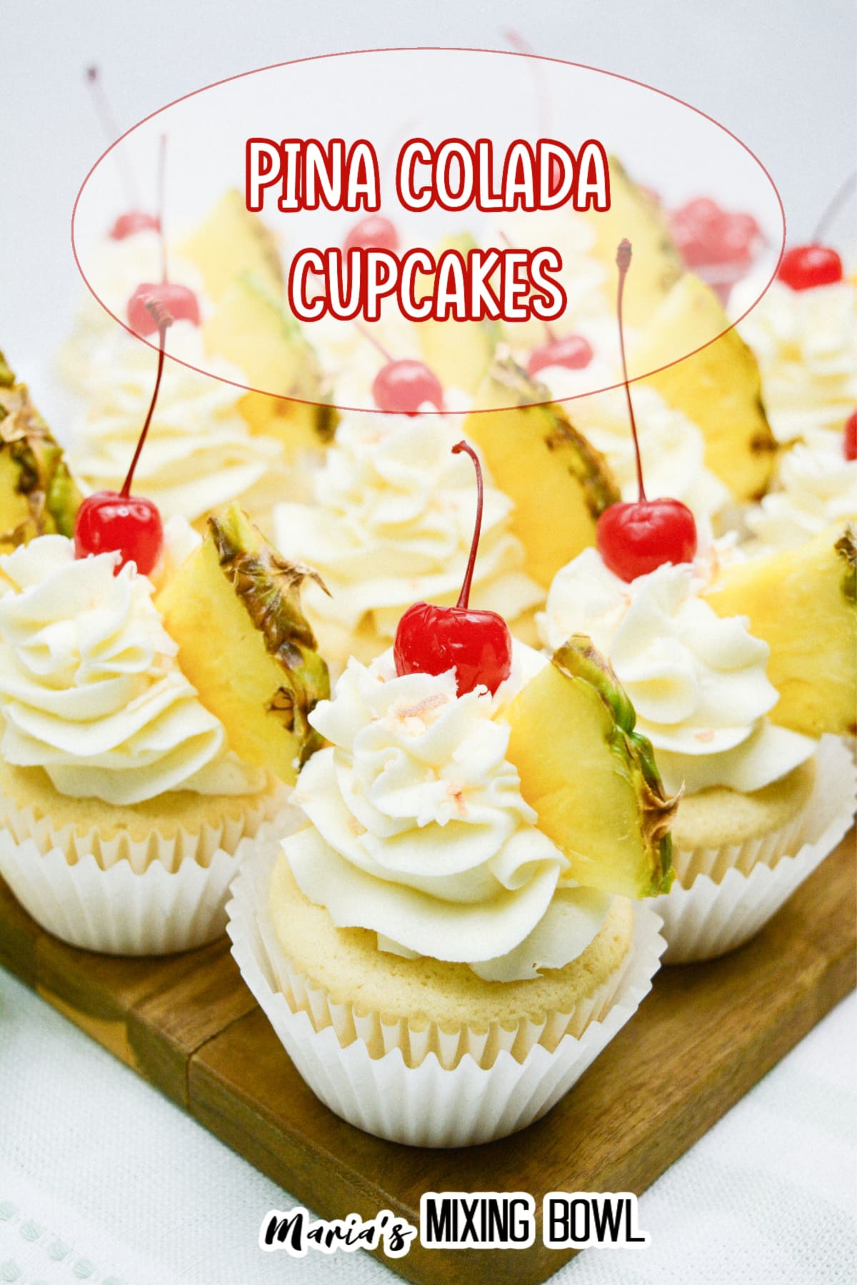 pina colada cupcakes on a wooden cutting board.