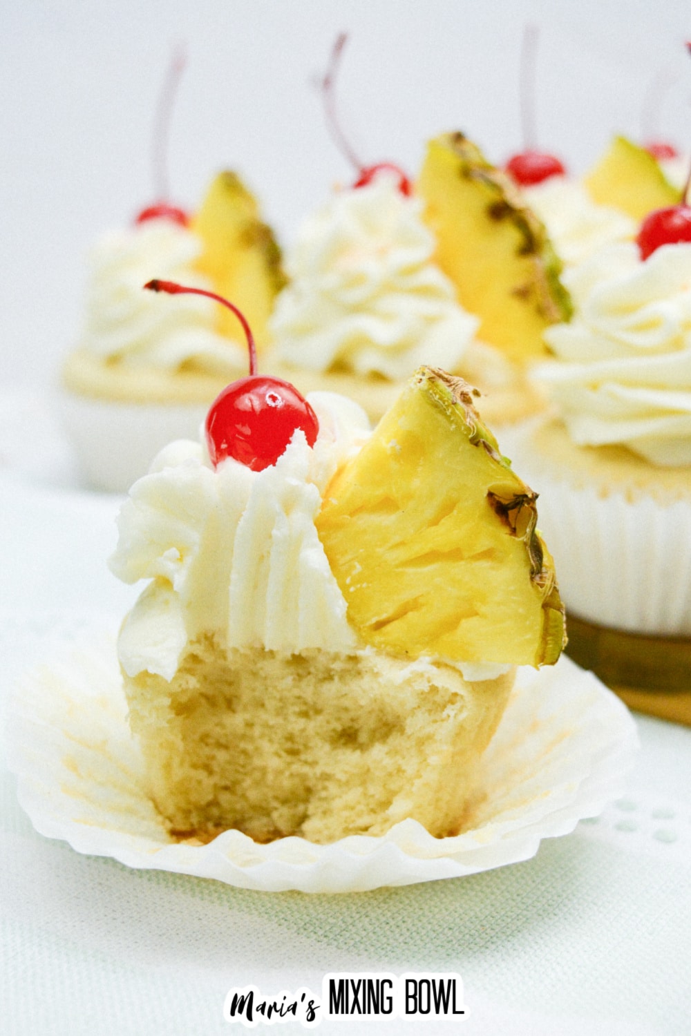 pina colada cupcake with a bite missing to see the inside.