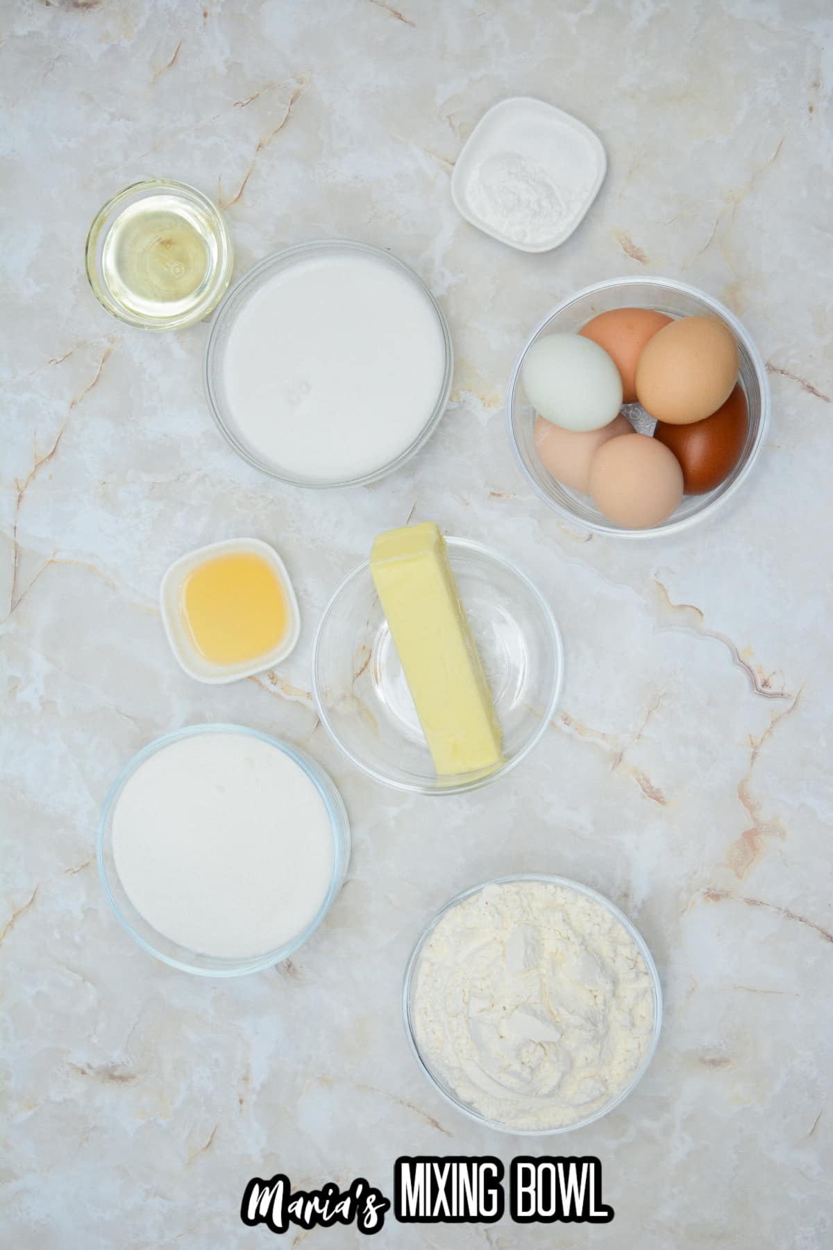 bowls of flour, sugar, eggs, salt, baking soda, butter, rum extract, and coconut milk.
