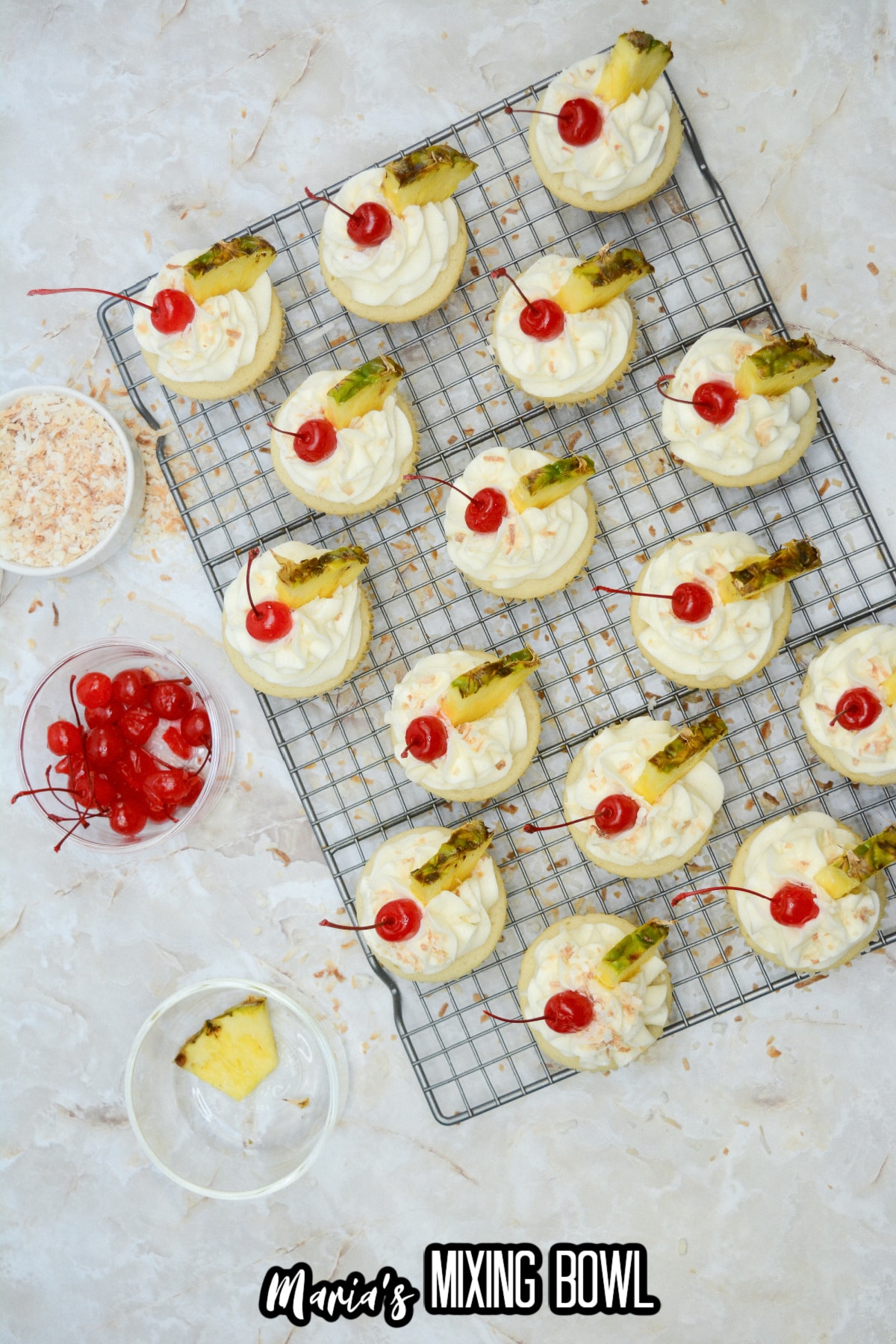 cupcakes being decorated on top of a wire cooling rack.