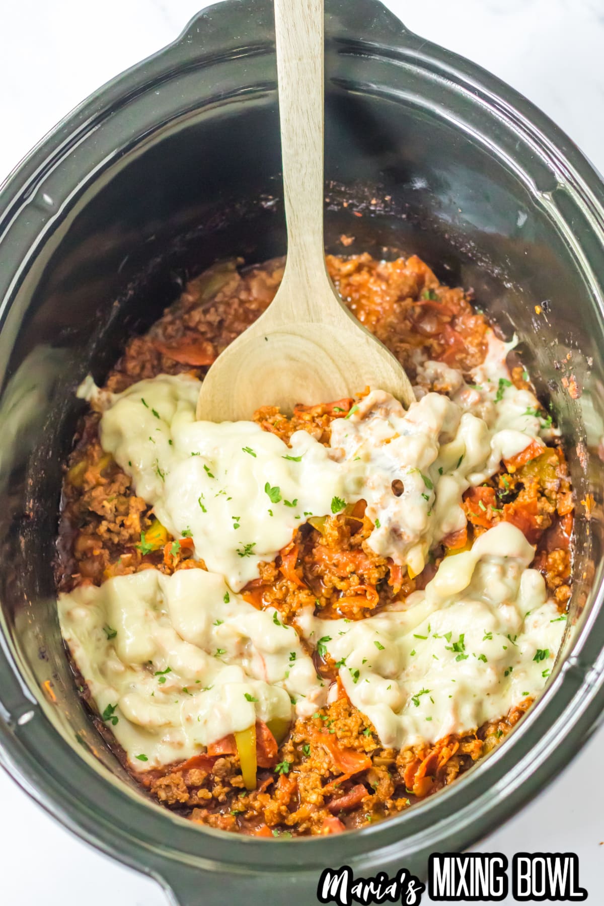 pizza sloppy joes topped with melted mozzarella cheese in a slow cooker.