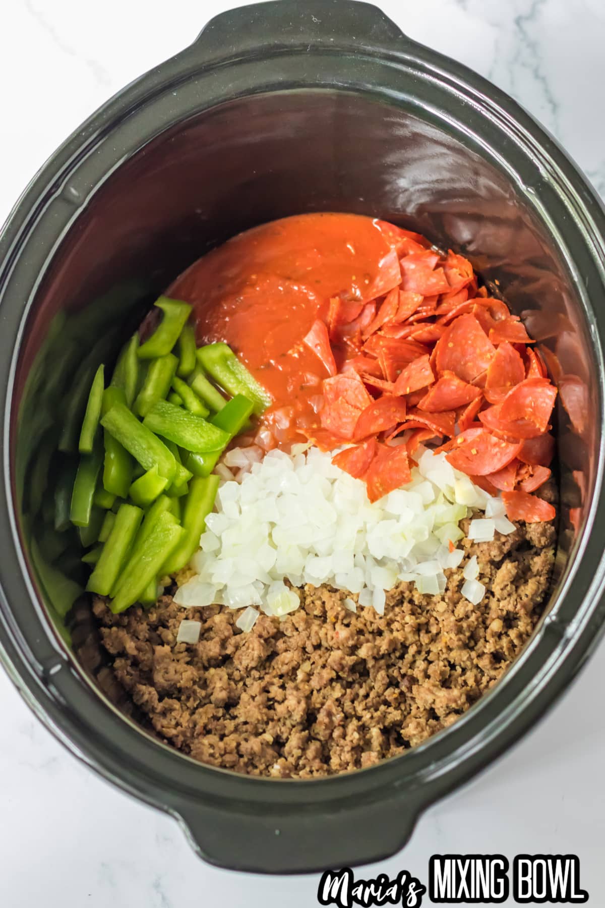 cooked ground beef, cooked italian sausage, pepperoni, sliced bell peppers, and diced onions in a slow cooker.
