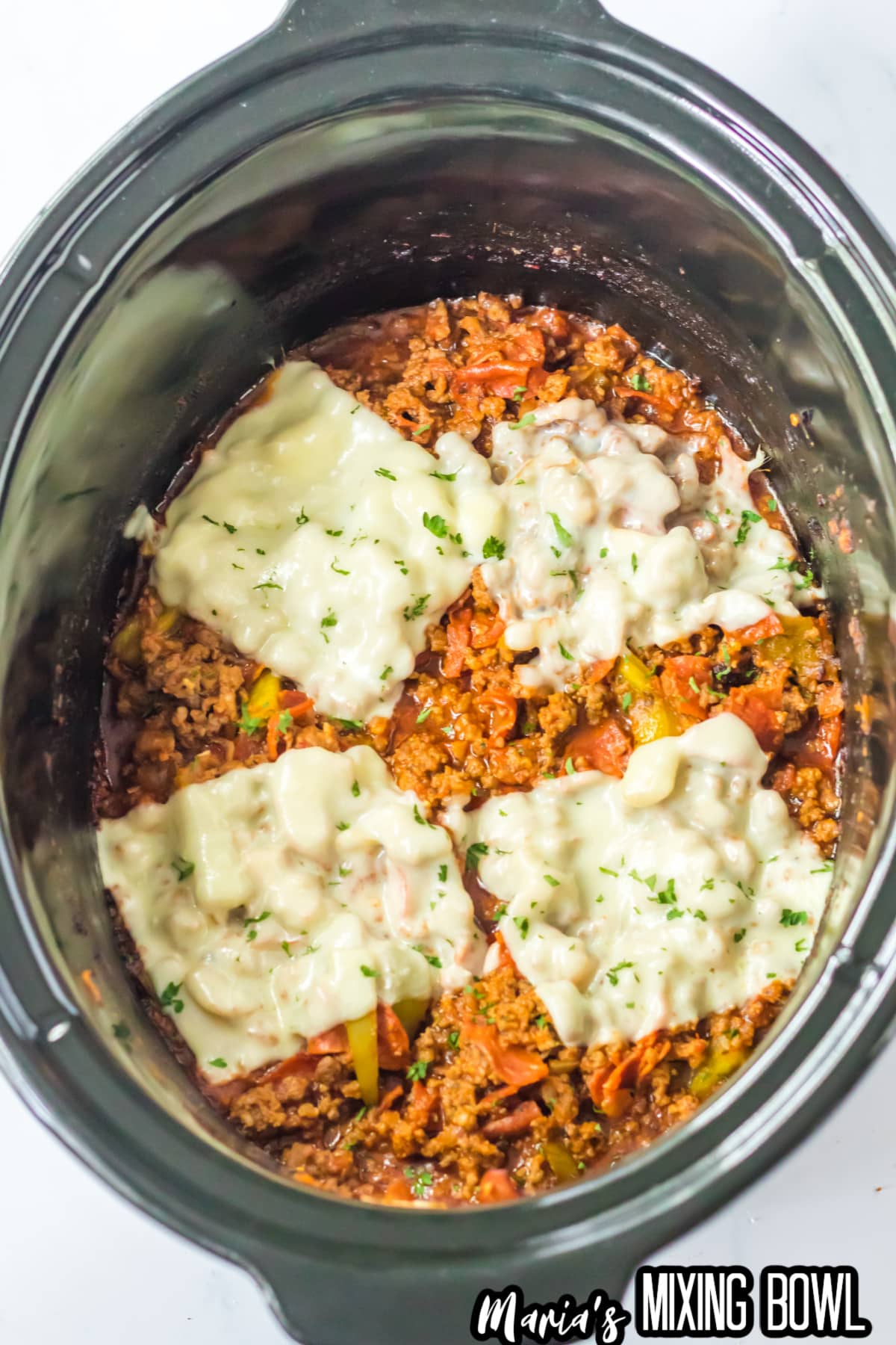 pizza sloppy joes topped with melted mozzarella cheese in a slow cooker.