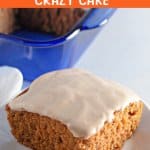 slice of pumpkin crazy cake topped with cream cheese frosting on a white plate.