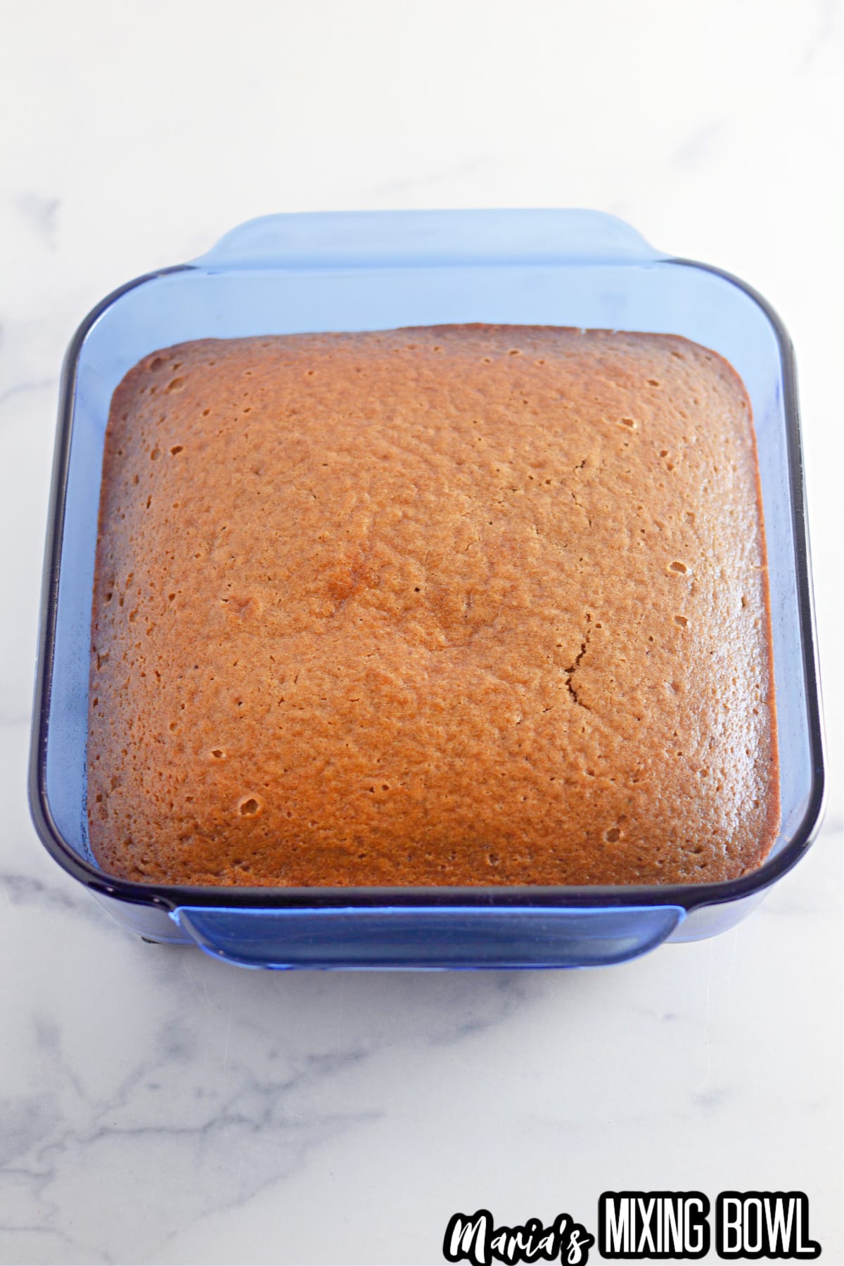 baked pumpkin cake in a square glass baking dish.