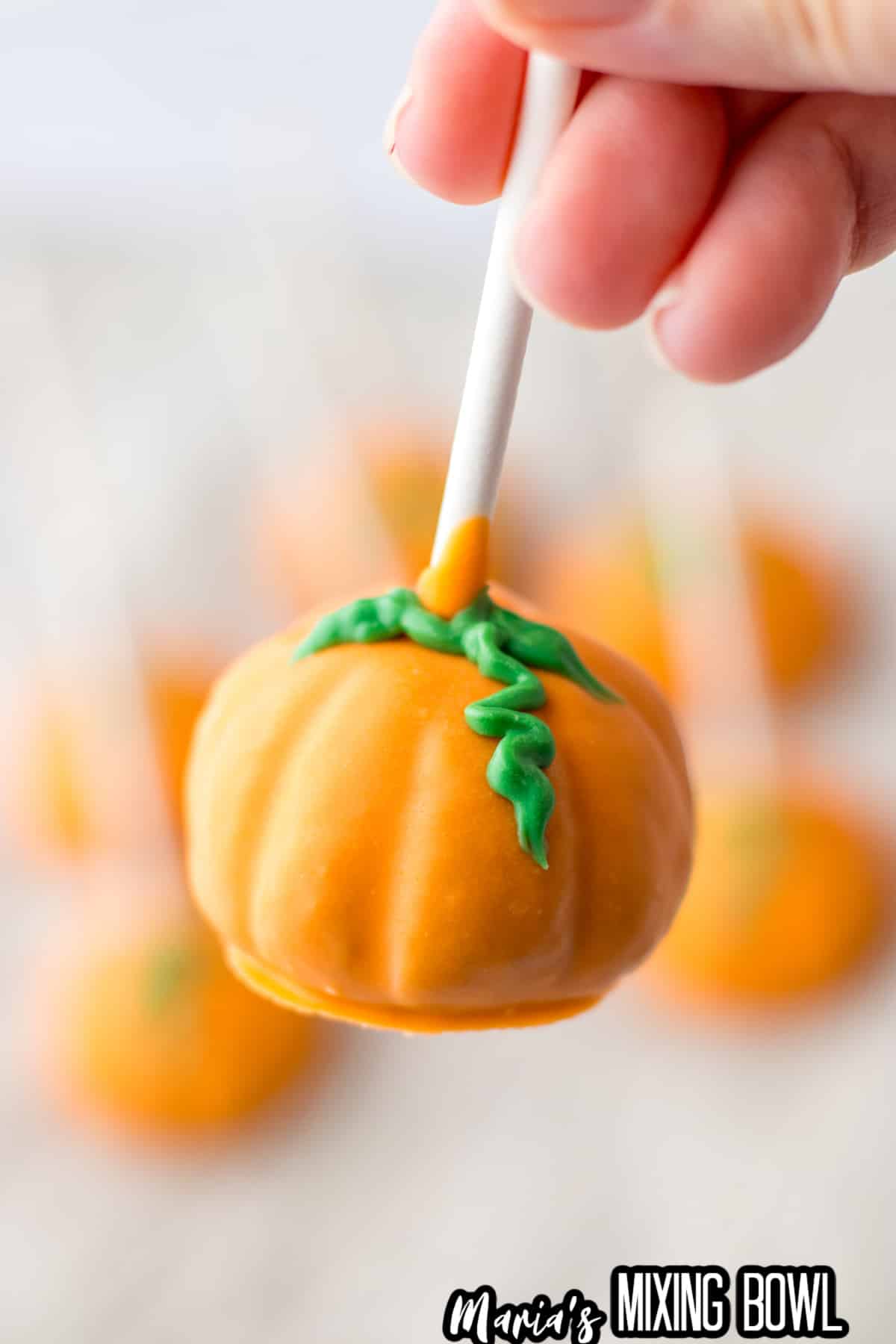pumpkin oreo truffle stick held in the air.