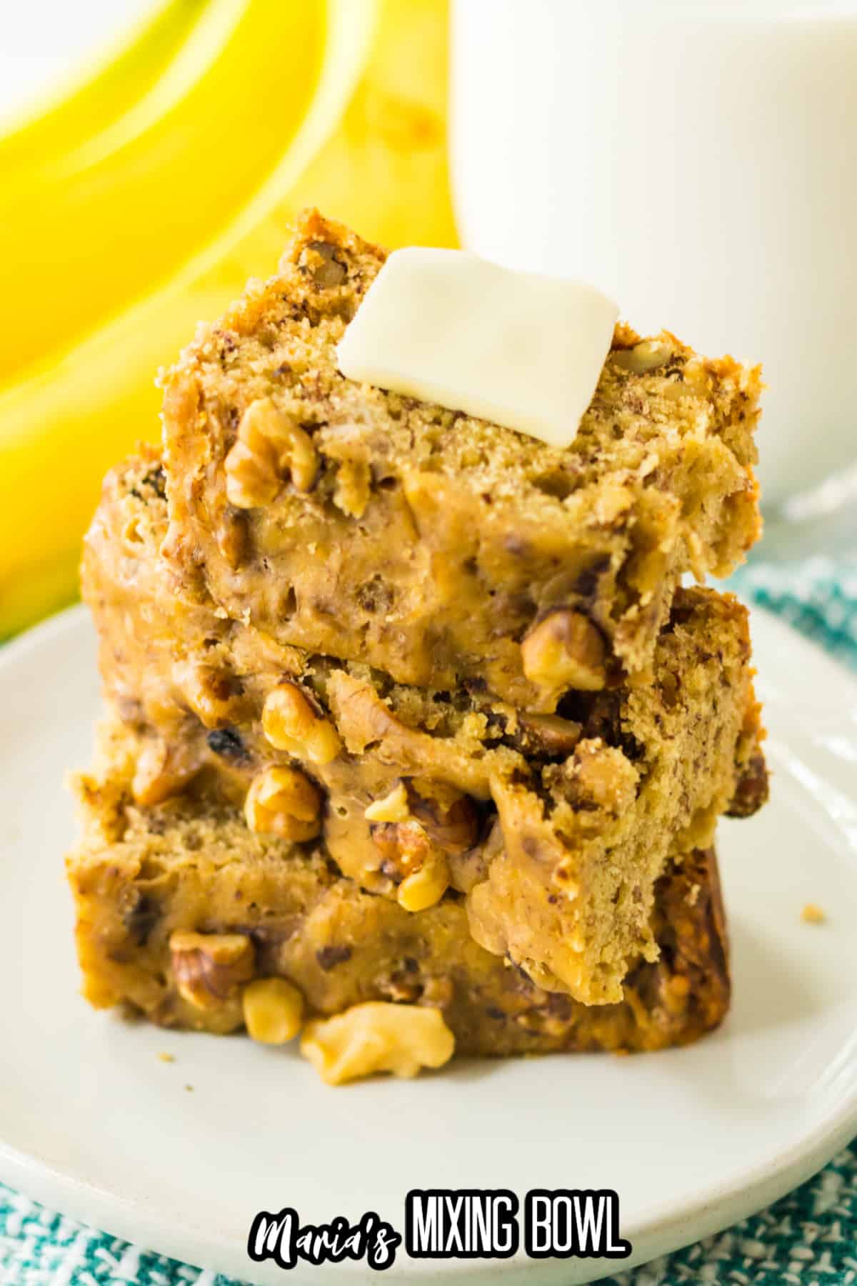 three slices of banana bread on on a plate with a pat of butter on the top.