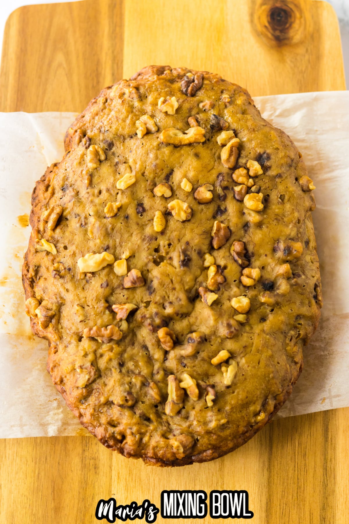 uncut banana bread loaf on a wooden cutting board.