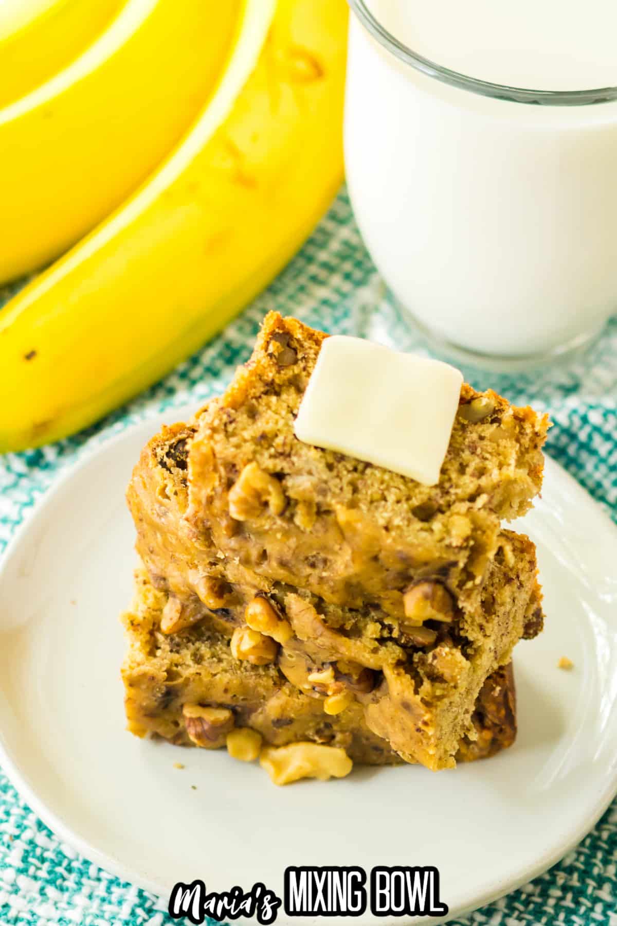 three slices of banana bread on a plate topped with a pat of butter.