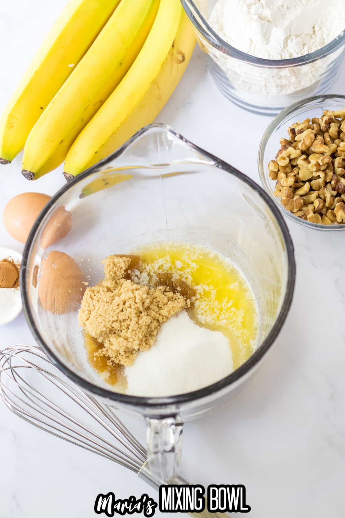 sugar, brown sugar, and melted butter in a glass mixing bowl.