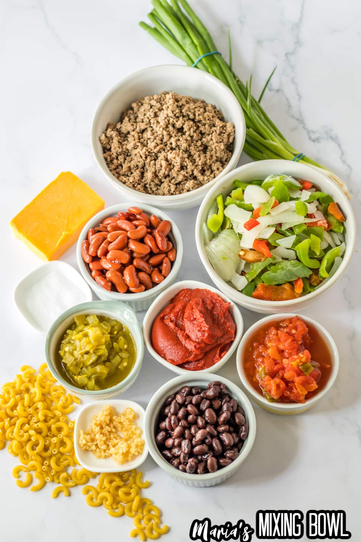 bowls of cooked ground beef, peppers and onion mixture, drained kidney and black beans, green chilies, tomato pasta, rotel, garlic, elbow noodles, cheddar cheese, and green onions.