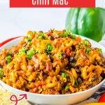 bowl full of chili mac garnished with green onions.