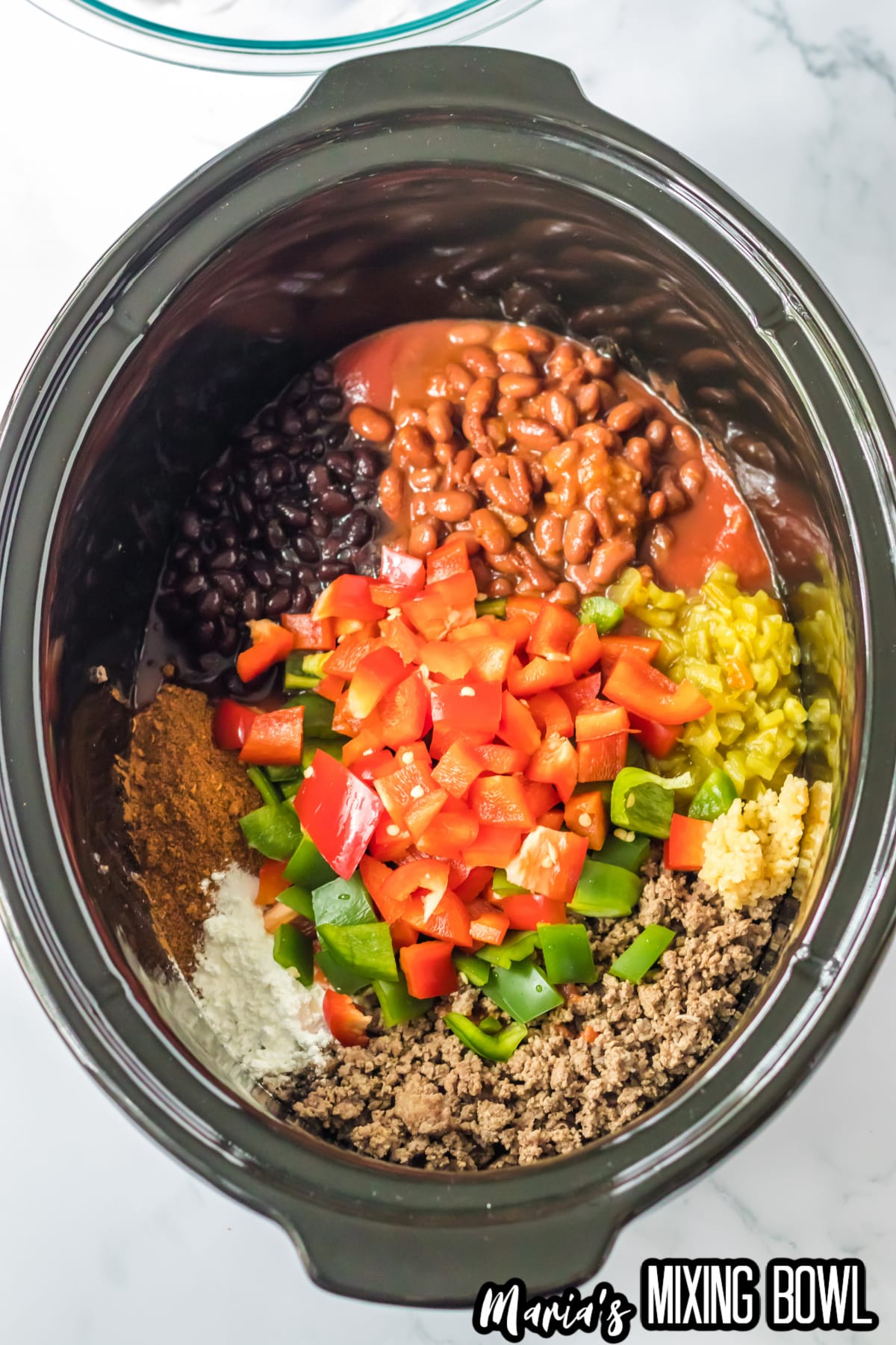 beans, cooked meat, seasonings, and vegetables in the slow cooker.