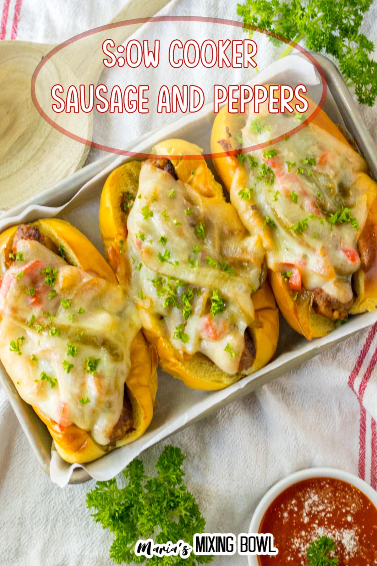 sausage and peppers on a hoagie roll with melted cheese on top on a metal serving tray.