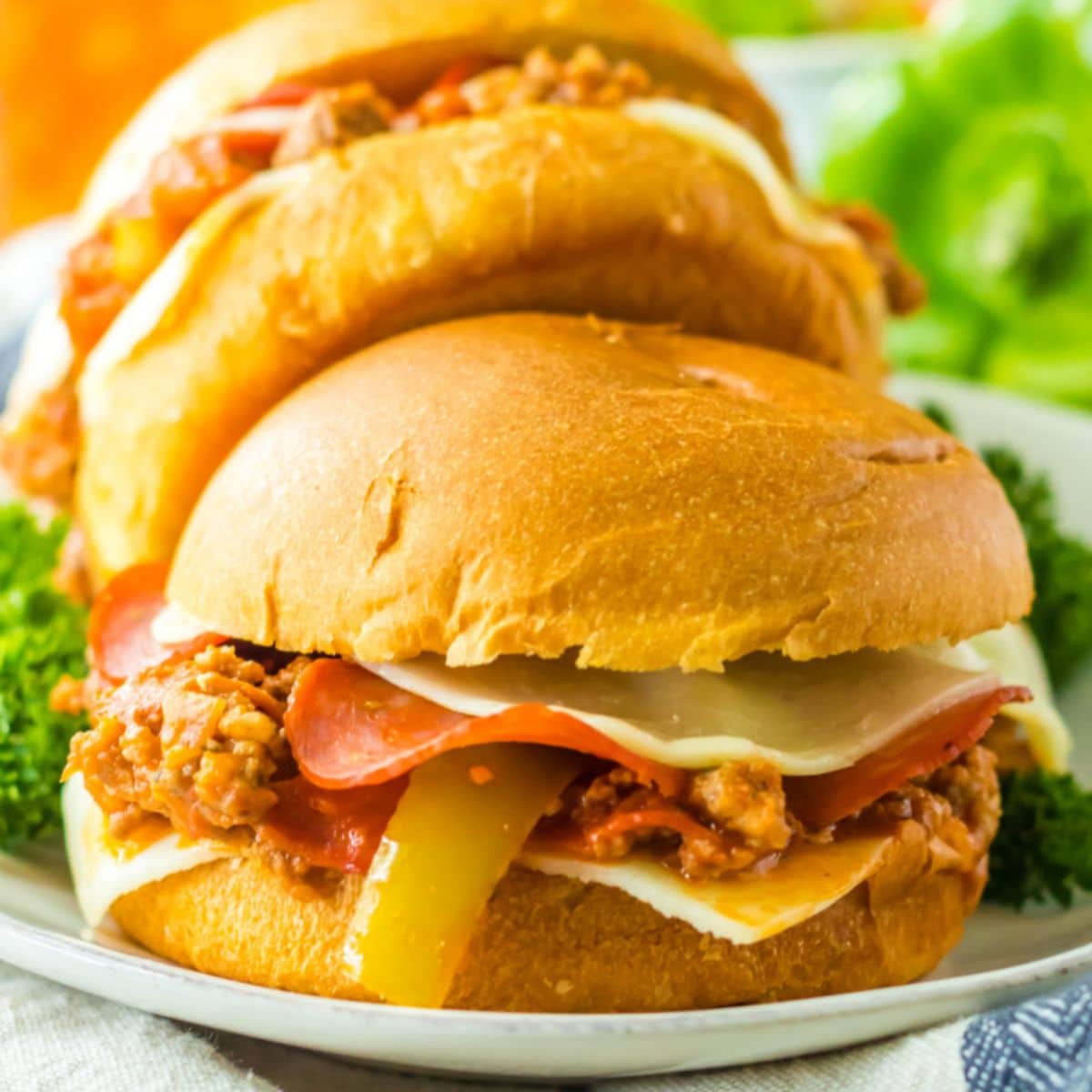 two slow cooker pizza sloppy joes on a white plate.