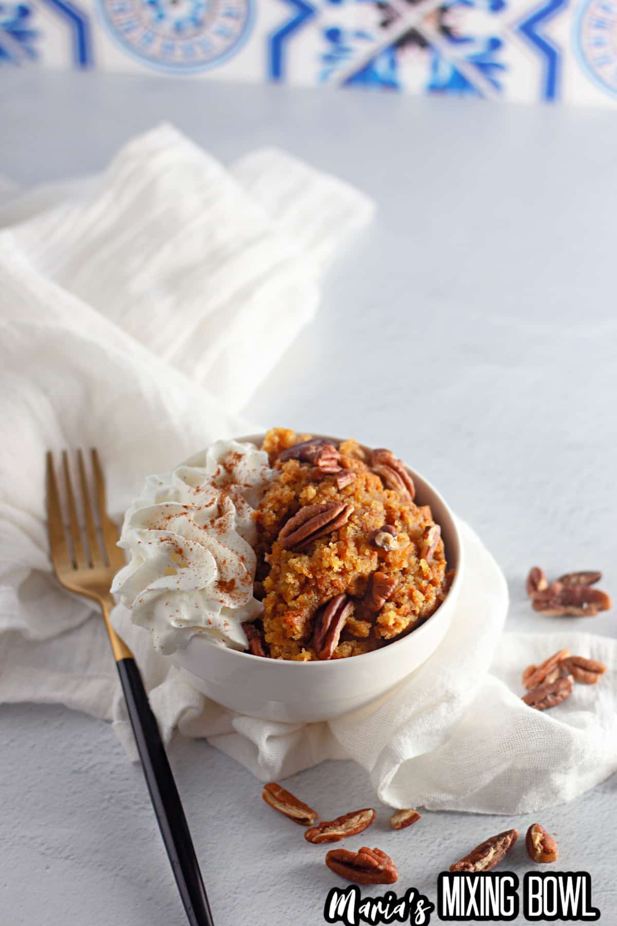 bowl full of slow cooker pumpkin cobbler topped with whipped cream.