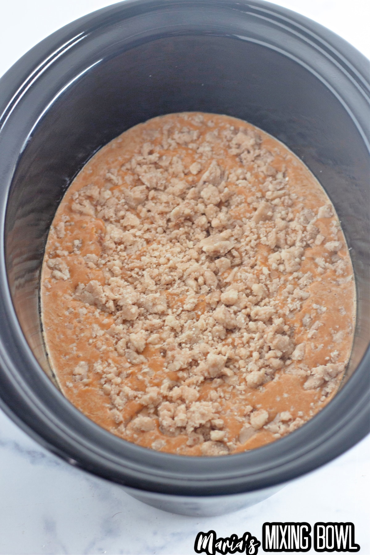 pumpkin mixture topped with cake mixture in the slow cooker.