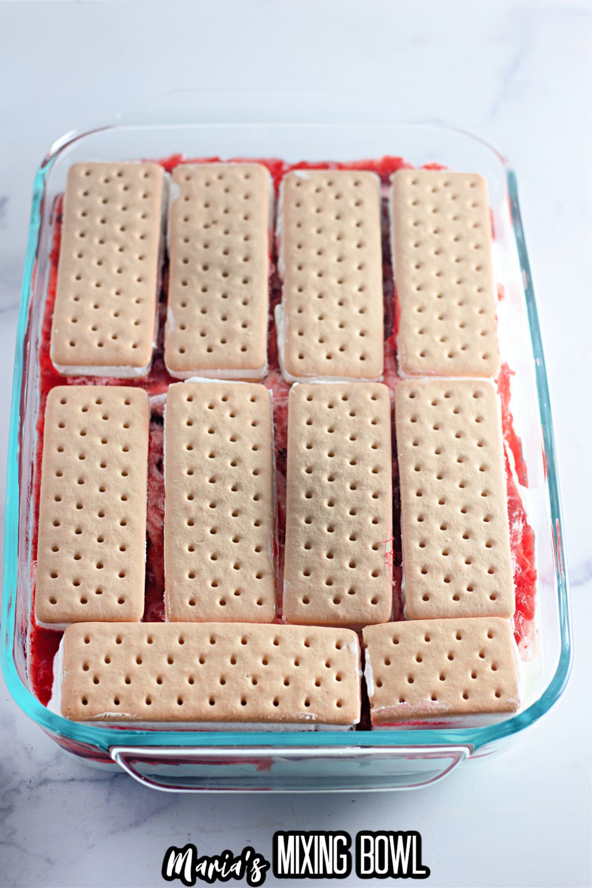 ice cream sandwiches being layered out into a glass baking dish.