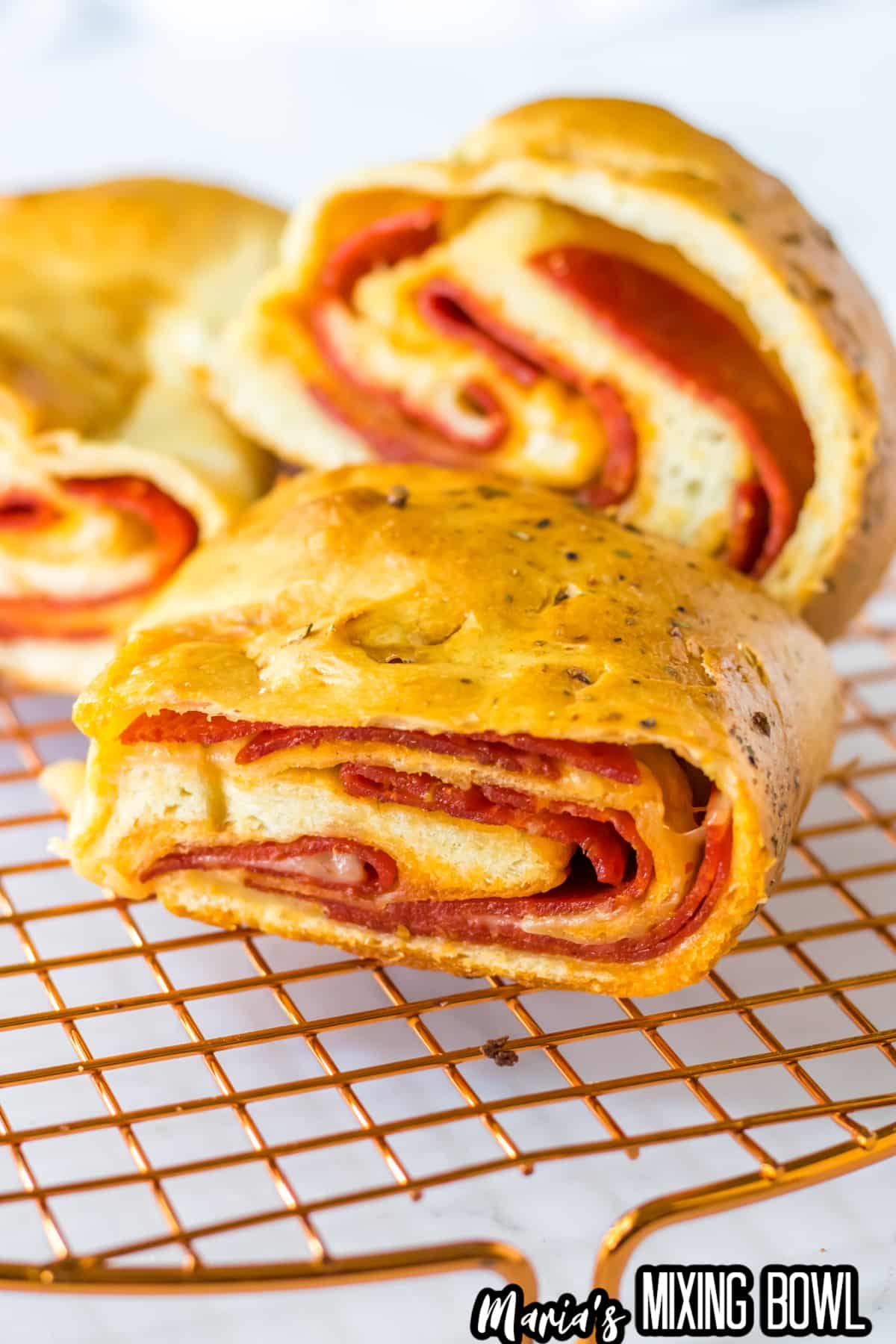 slices of stuffed pepperoni bread cooling on a wire rack.