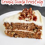 slice of apple spice cake topped with cream cheese frosting on a white plate.