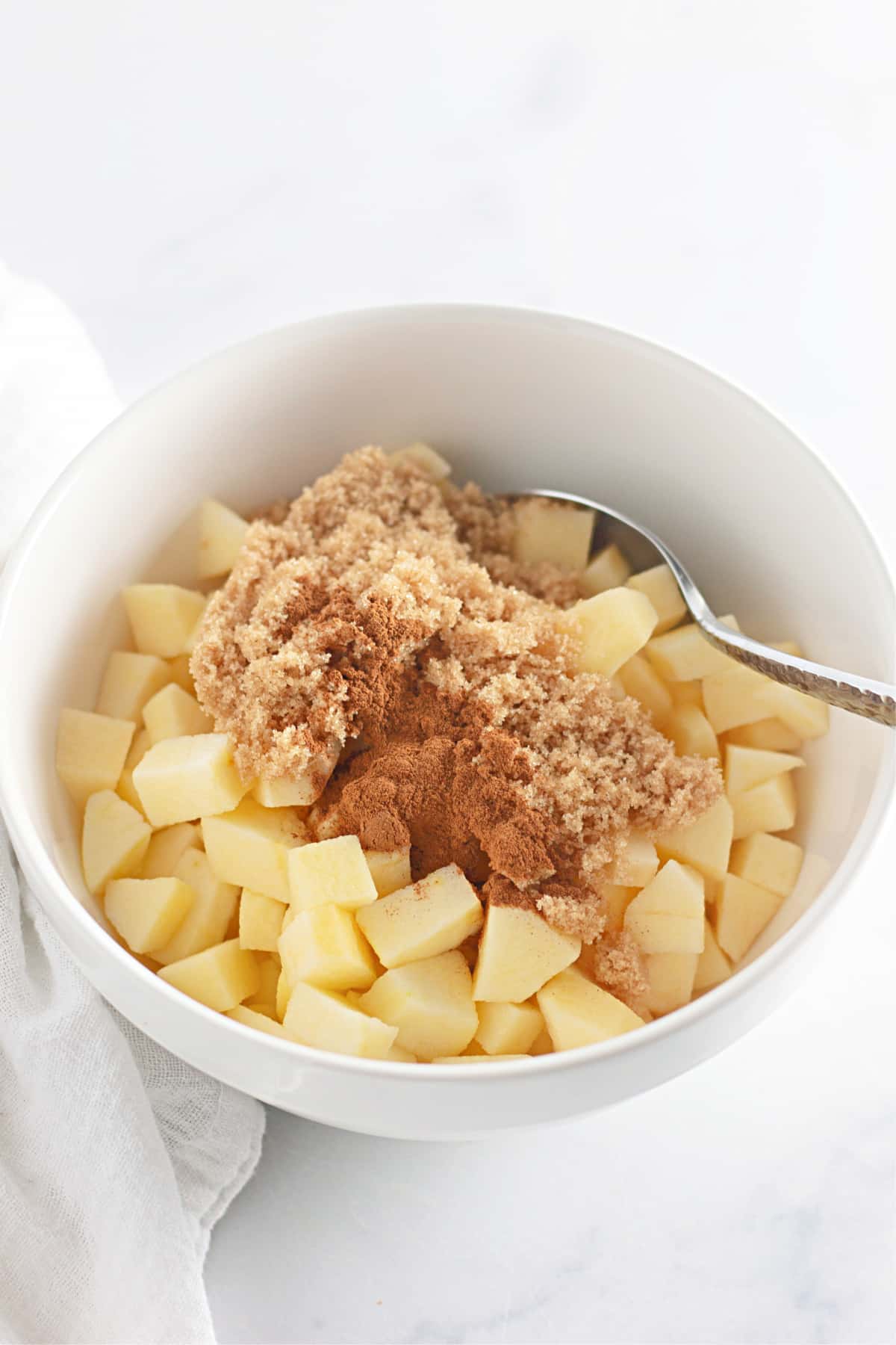 apples, brown sugar, and cinnamon in a bowl.