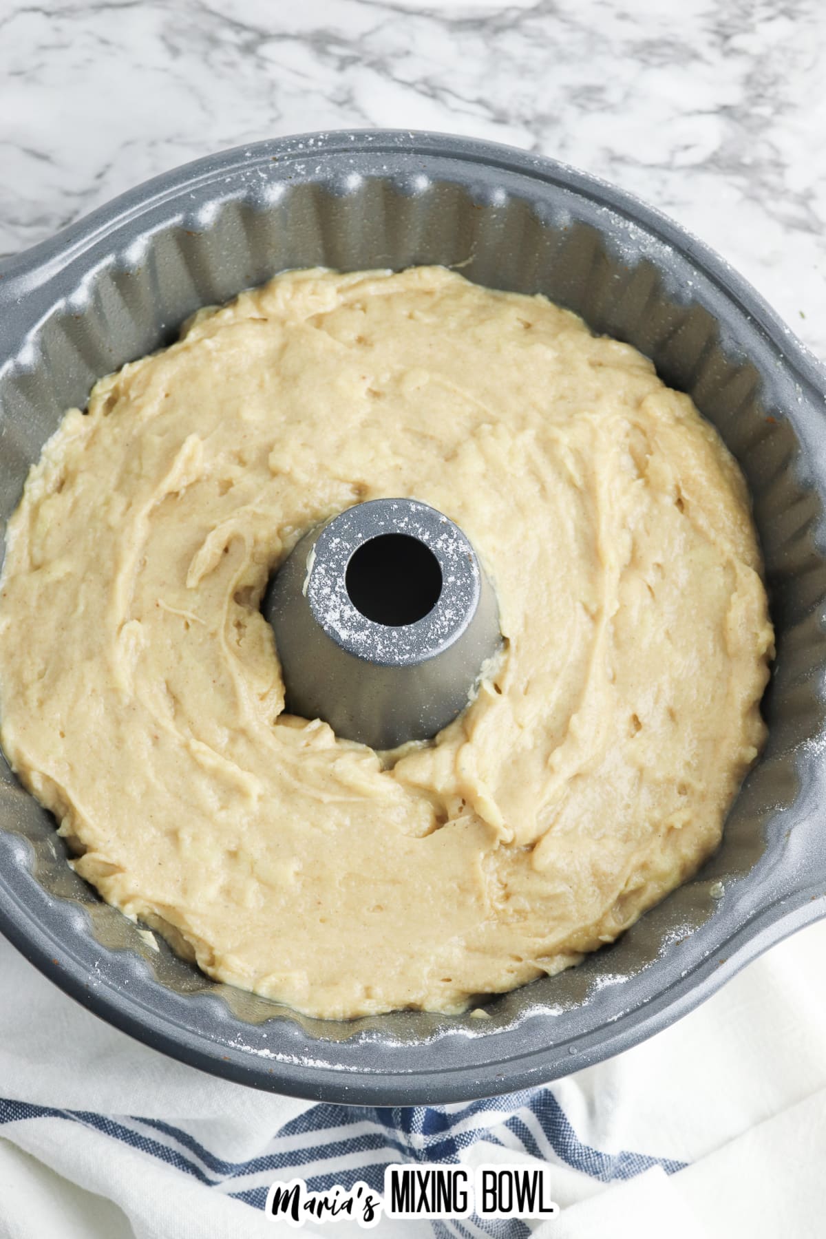 cake batter spread into a flouted bundt cake pan.