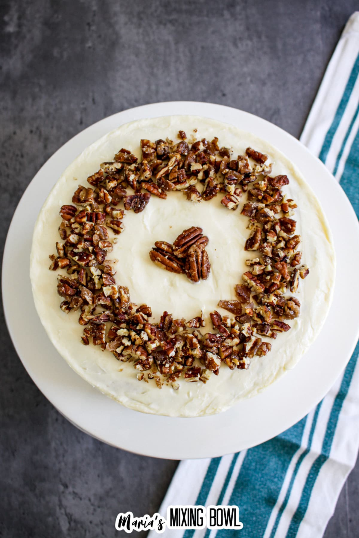 uncut apple spice cake topped with caramelized pecans.