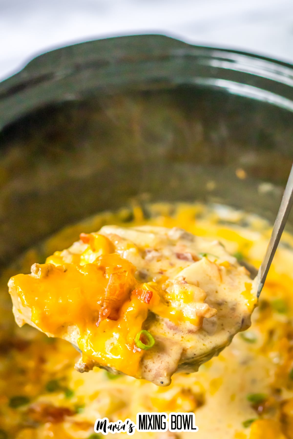 ladle full of bacon cheeseburger soup held above the slow cooker.