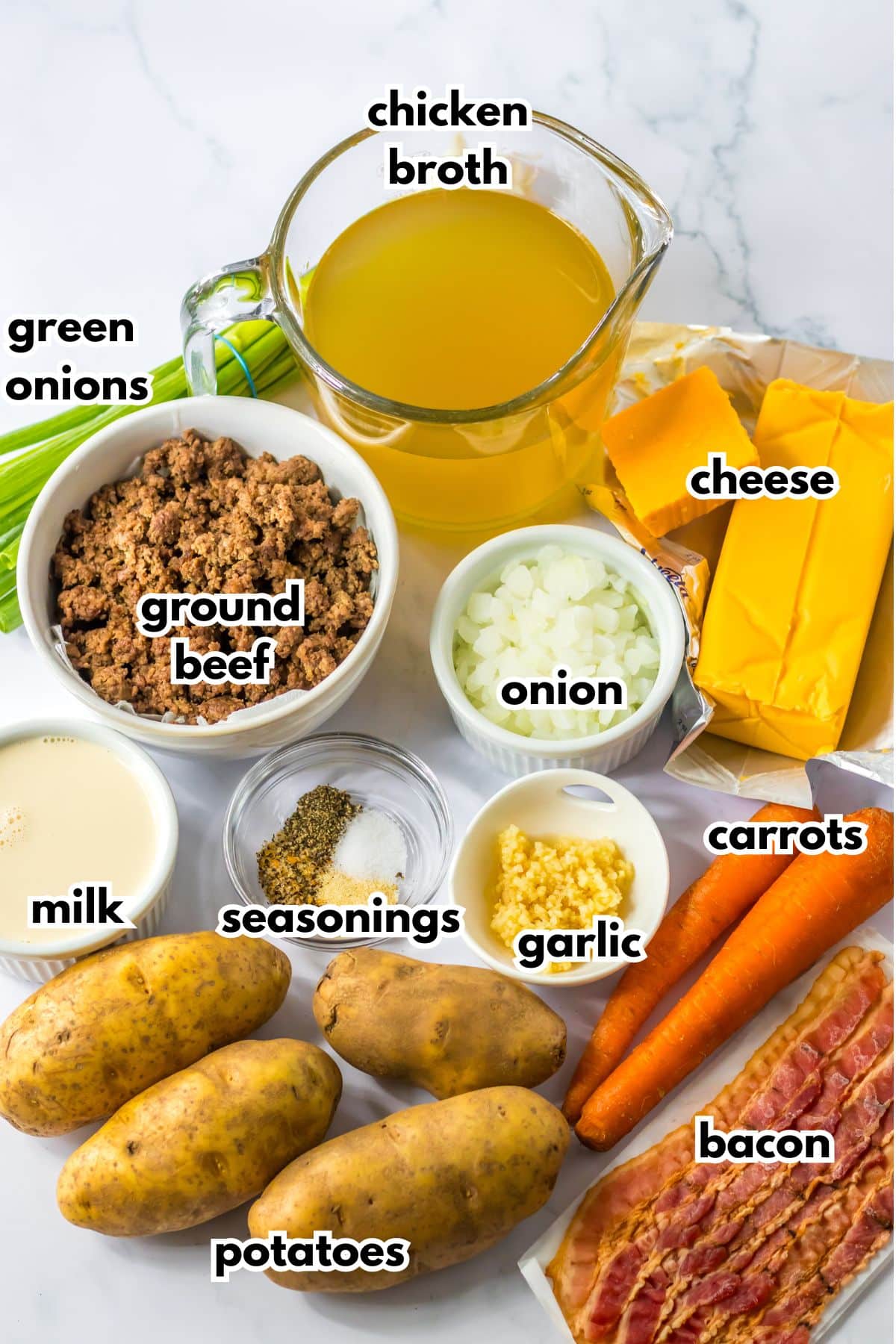 bowls of chicken broth, ground beef, milk, seasoning, onions, garlic, green onions, cheese, potatoes, carrots and bacon.