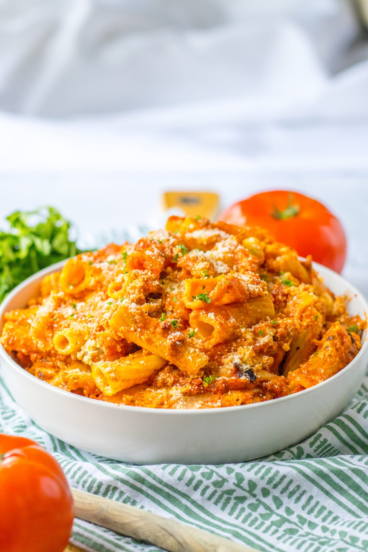 bowl full of slow cooker baked ziti topped with grated parmesan cheese.