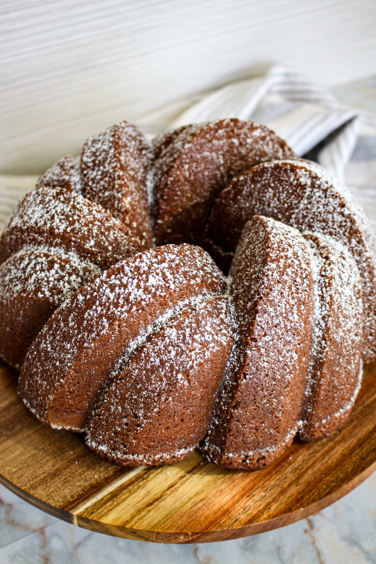 uncut bundt cake on a wooden cutting board.