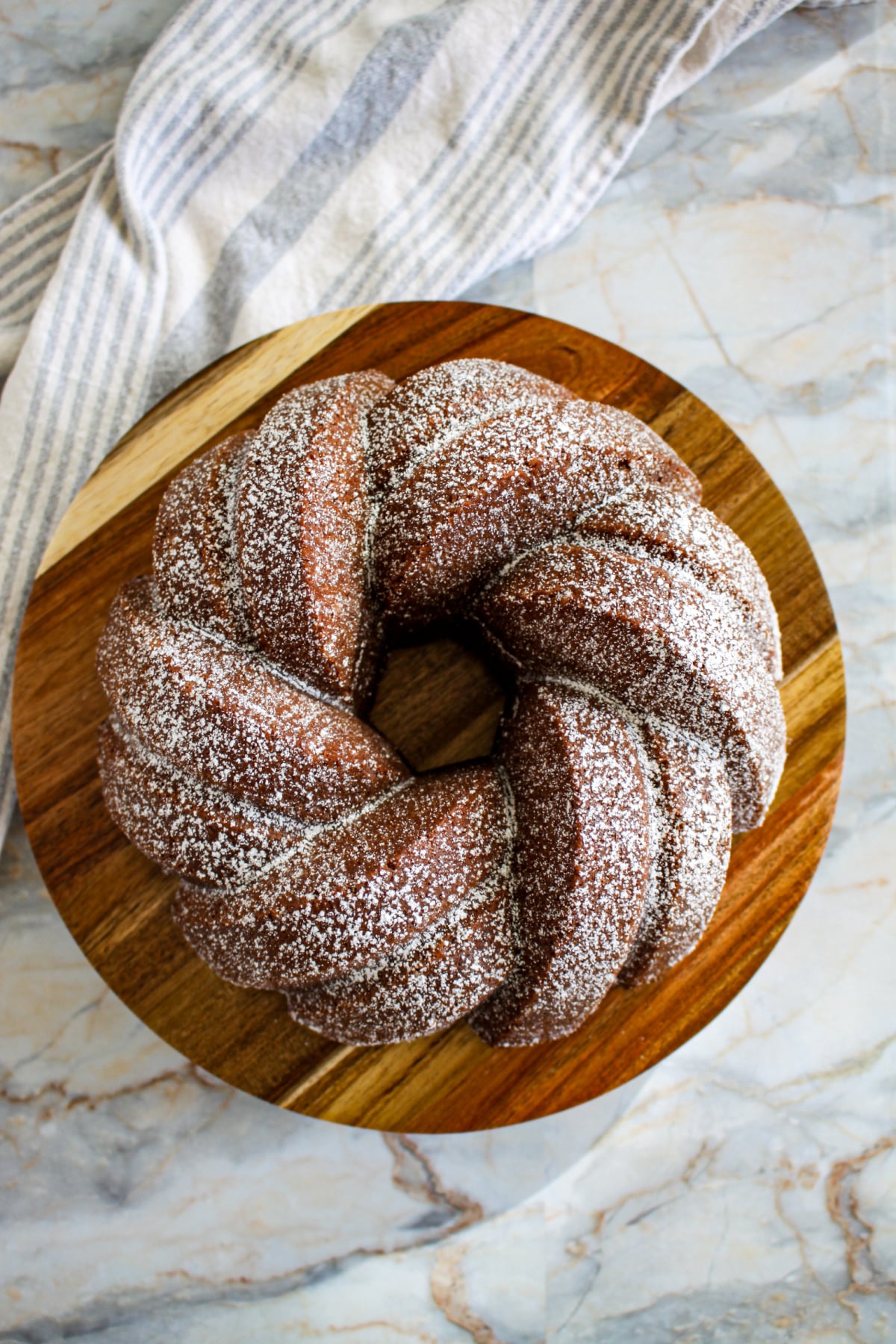 uncut bundt cake on a wooden cutting board.