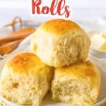 three cafeteria rolls stacked on a small plate.