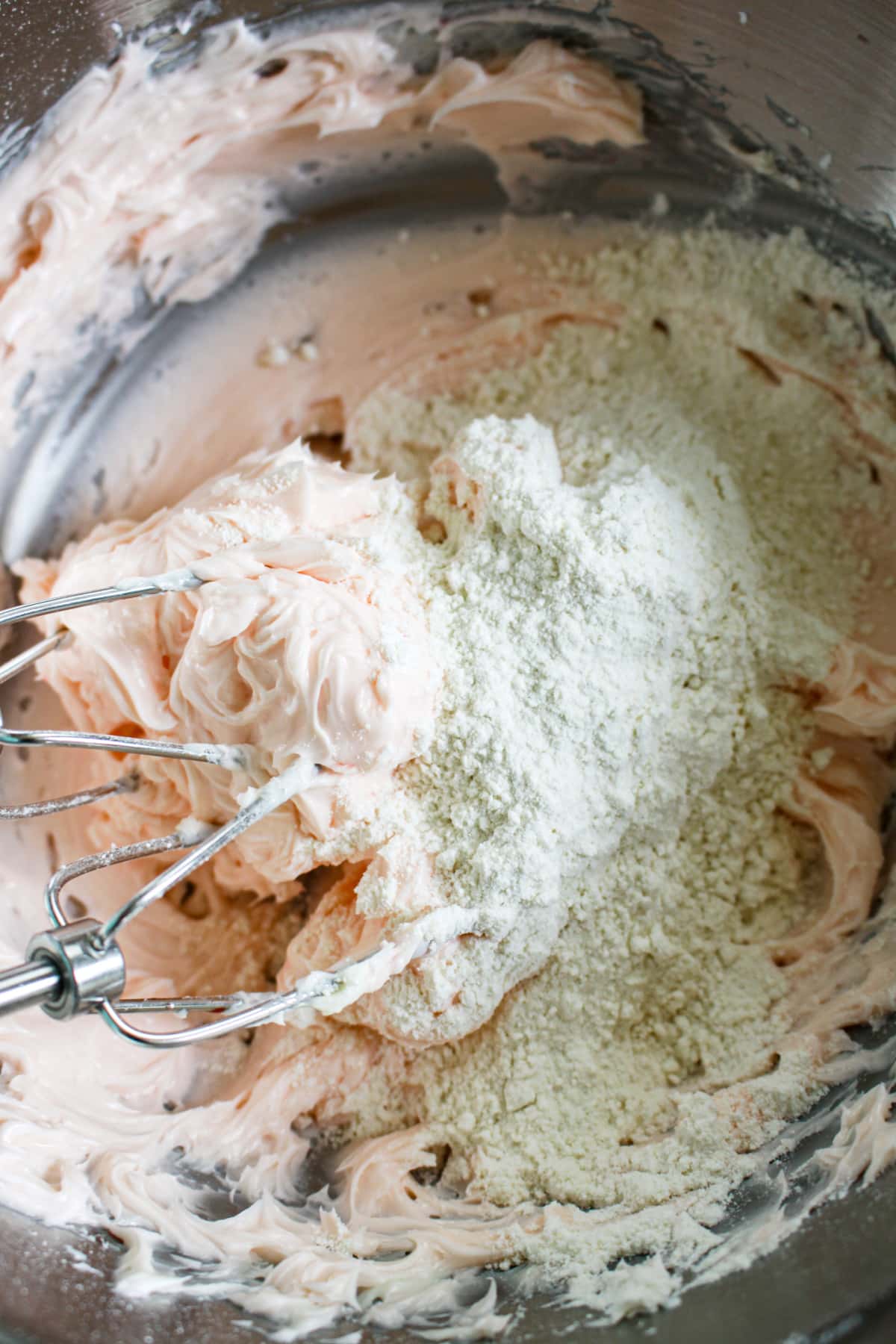 flour being added to the mixing bowl full of wet ingredients.