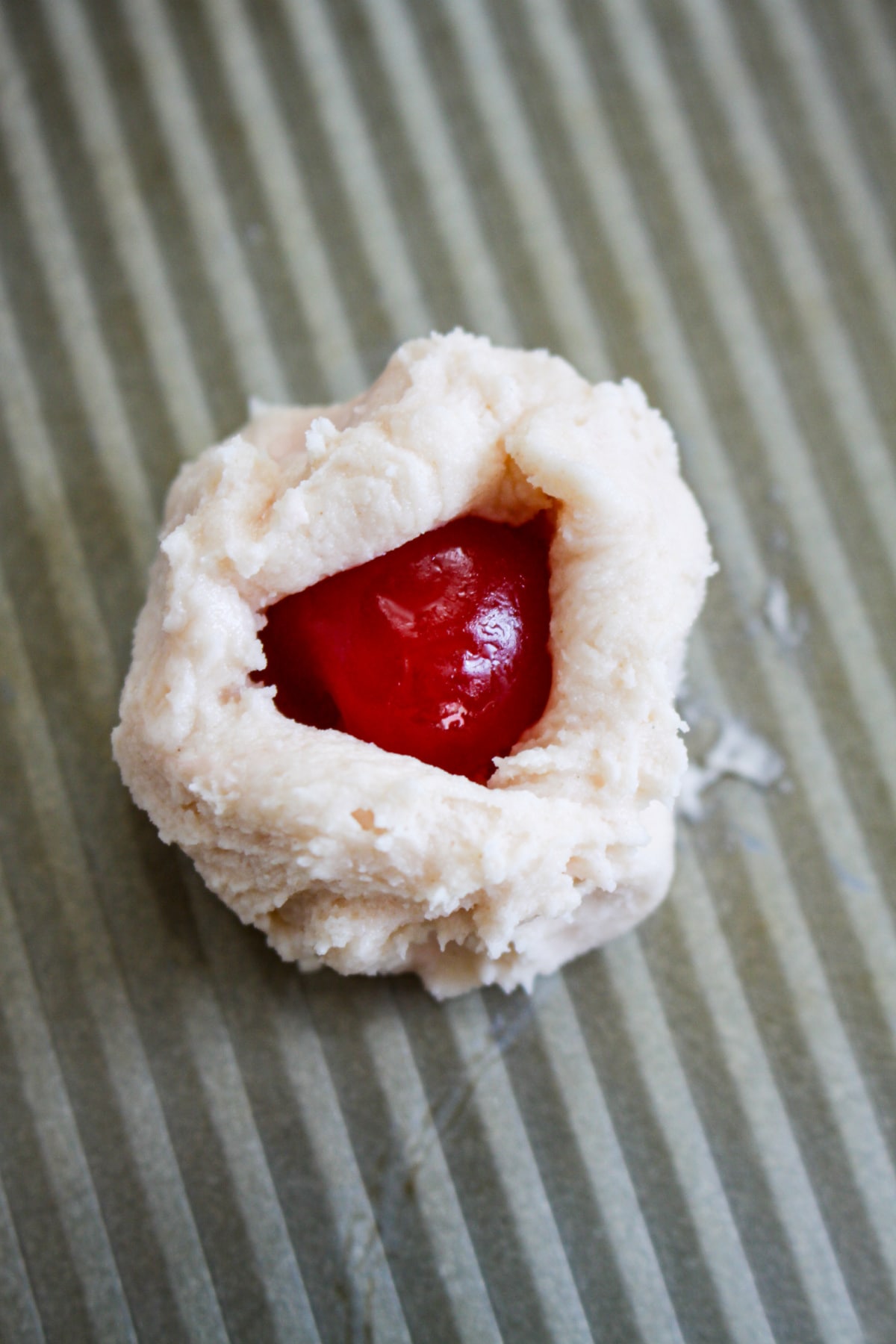 cherry being wrapped in raw cookie dough.