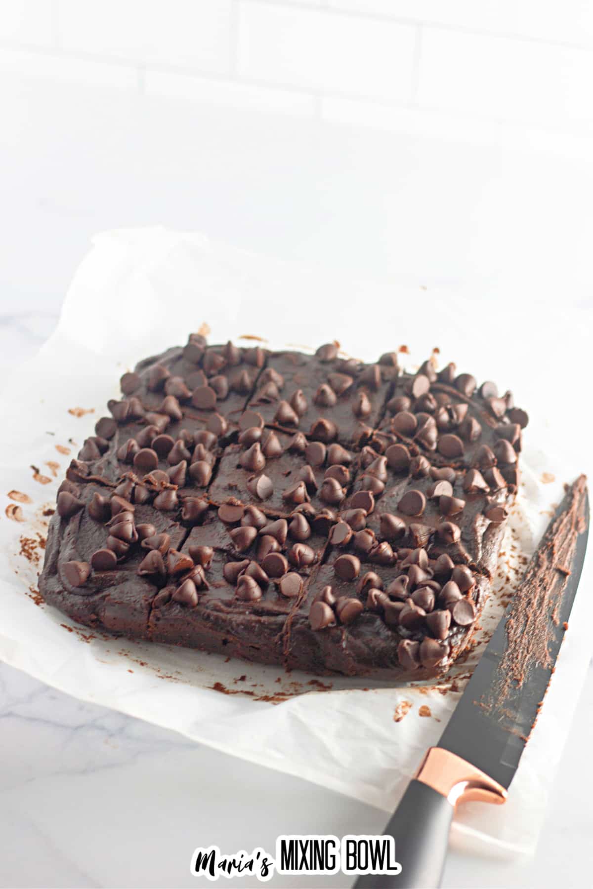 chocolate pumpkin brownies being cut into squares.