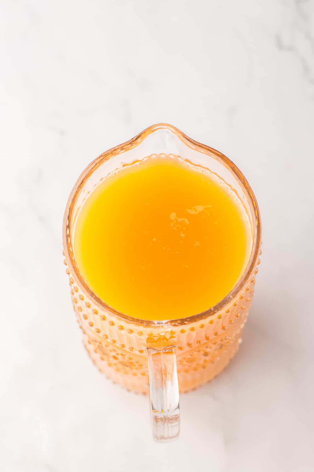 punch being mixed in a 2 quart glass pitcher.