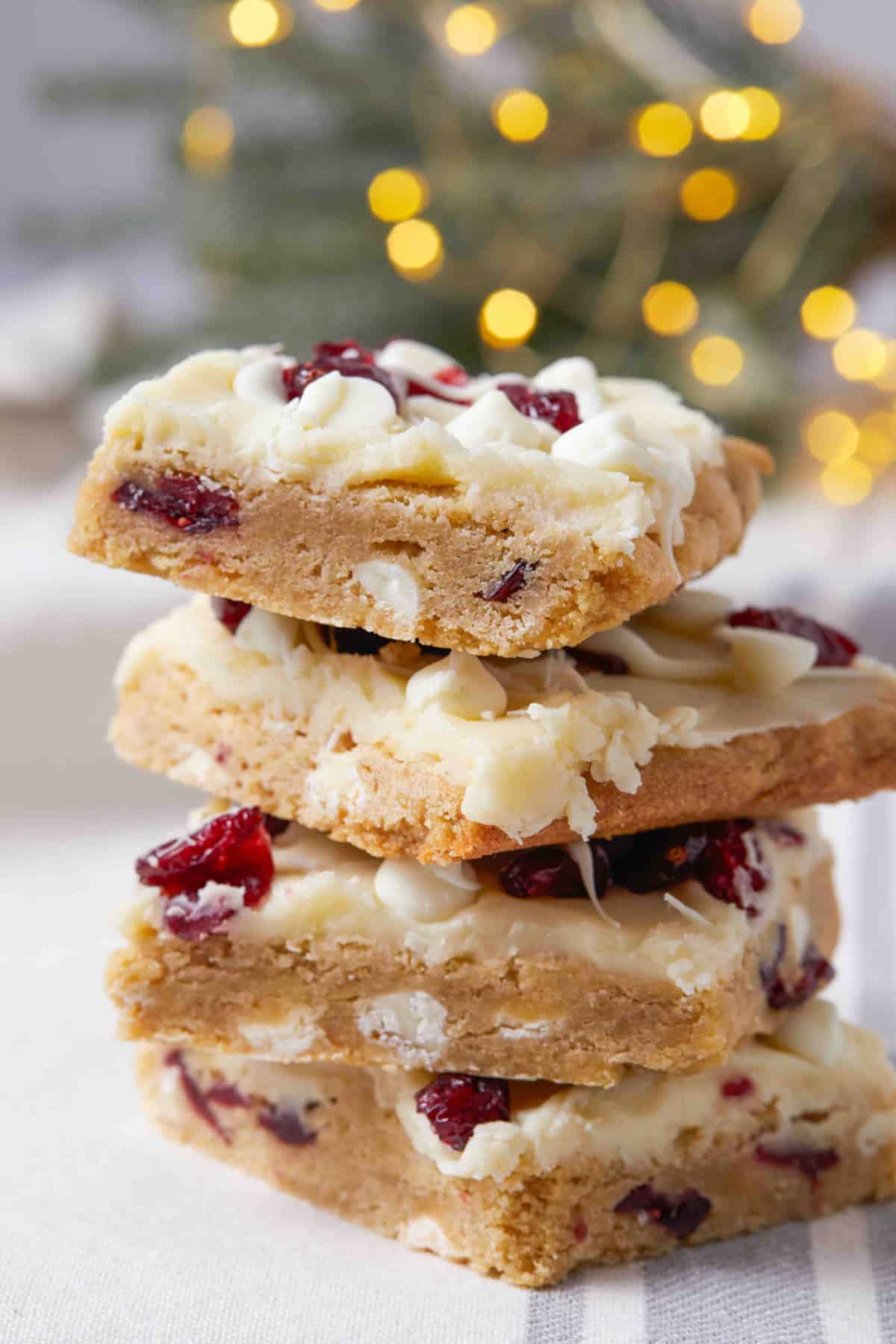 four cranberry bliss bars stacked on top of each other.